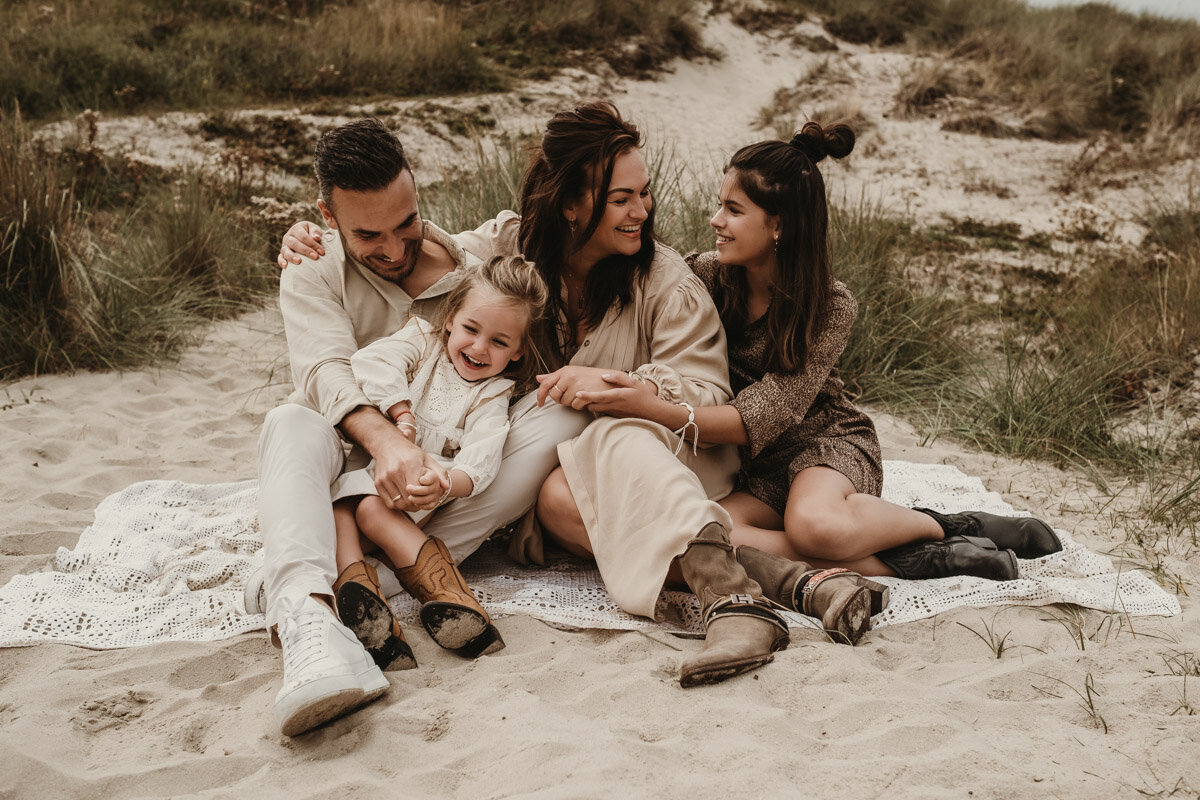 gezin op een kleedje in de duinen