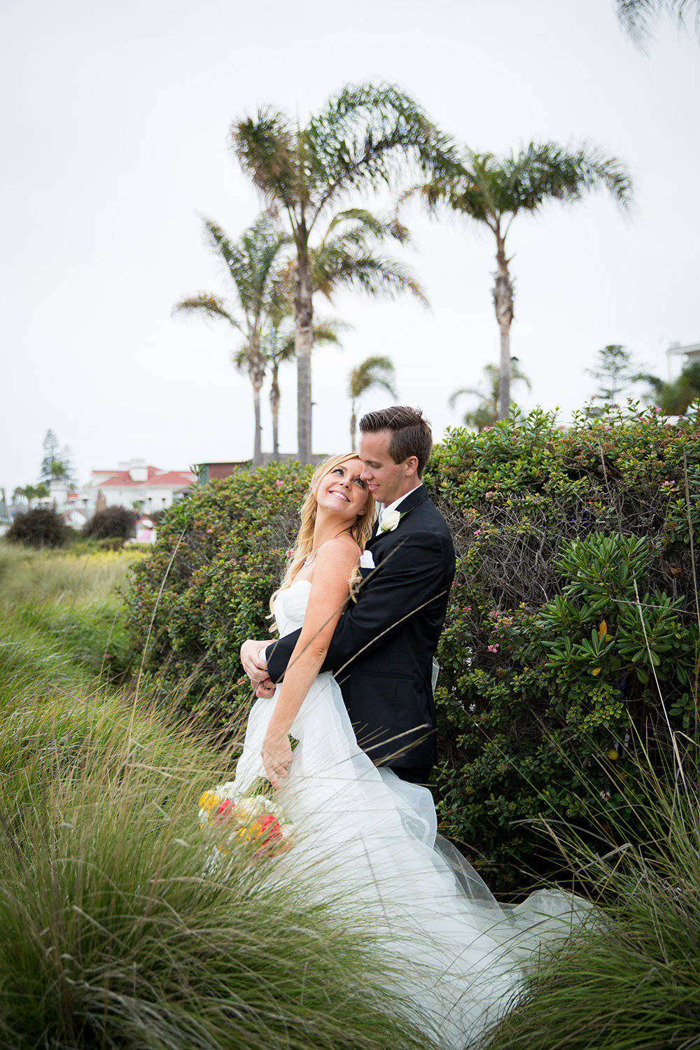 Bride and groom wedding portrait in tall grass at the sand dunes in Coronado