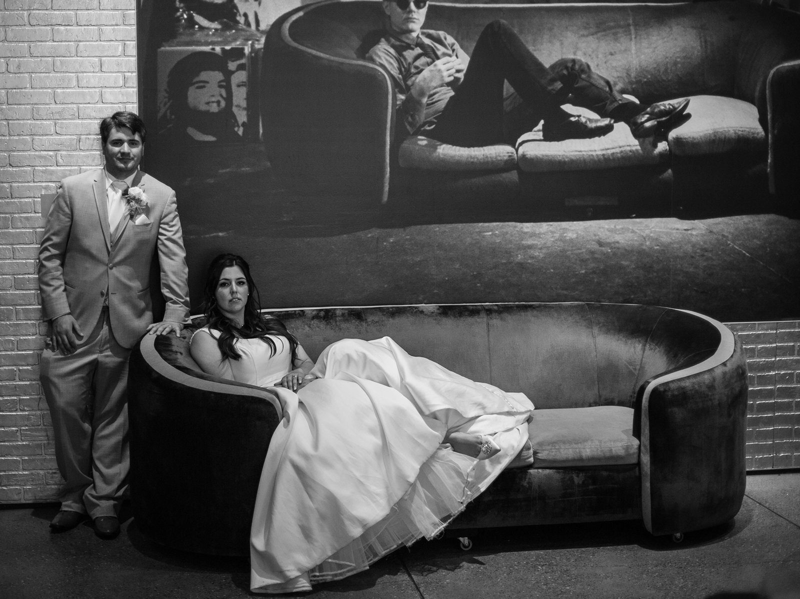 Bride and groom pose on a couch at their Andy Warhol Museum wedding reception
