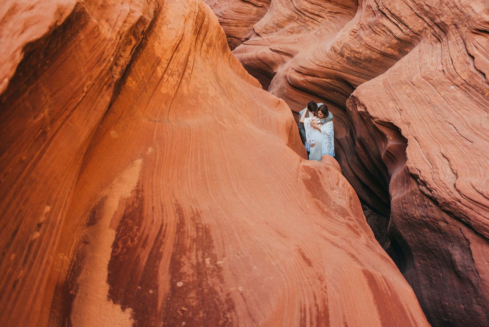 Elopement couple embraces in a red rock slot canyon