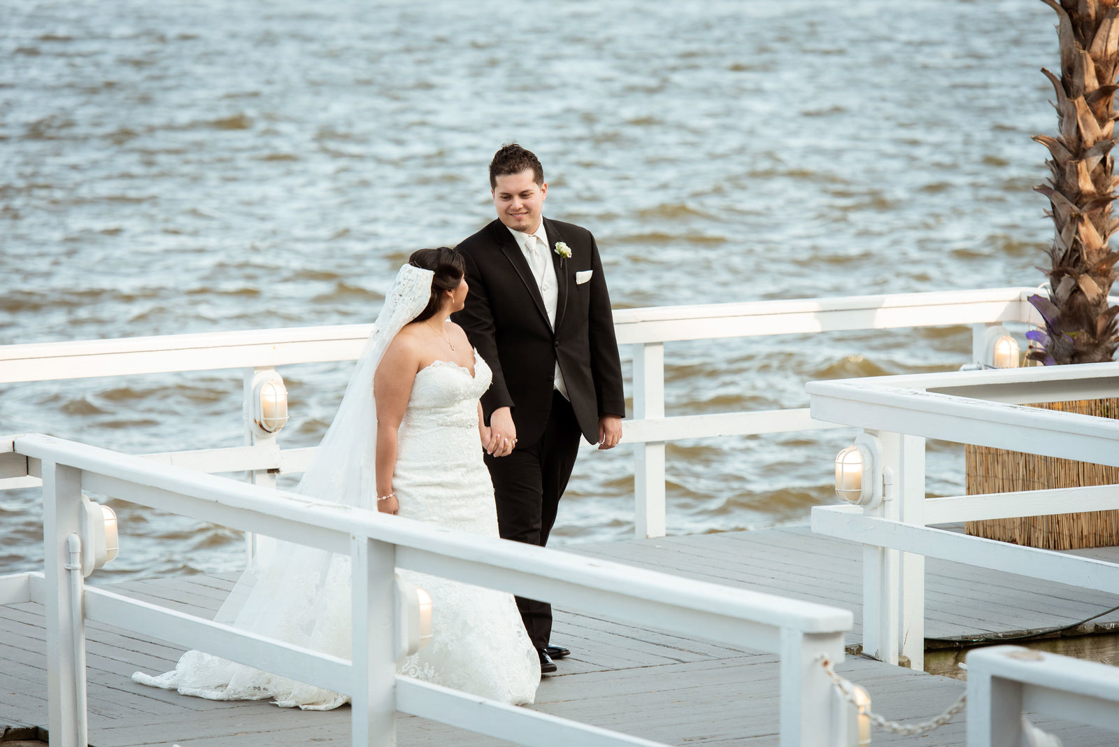 Bride and groom walking on dock at Chateau La Mer