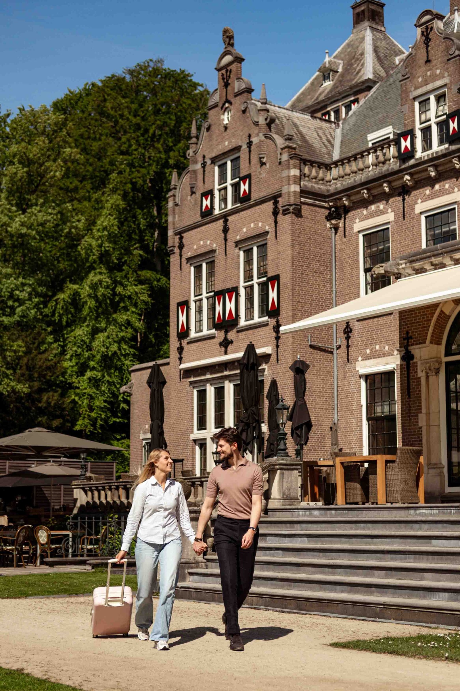 koppel verlaat sfeervol landgoed hotel met koffers