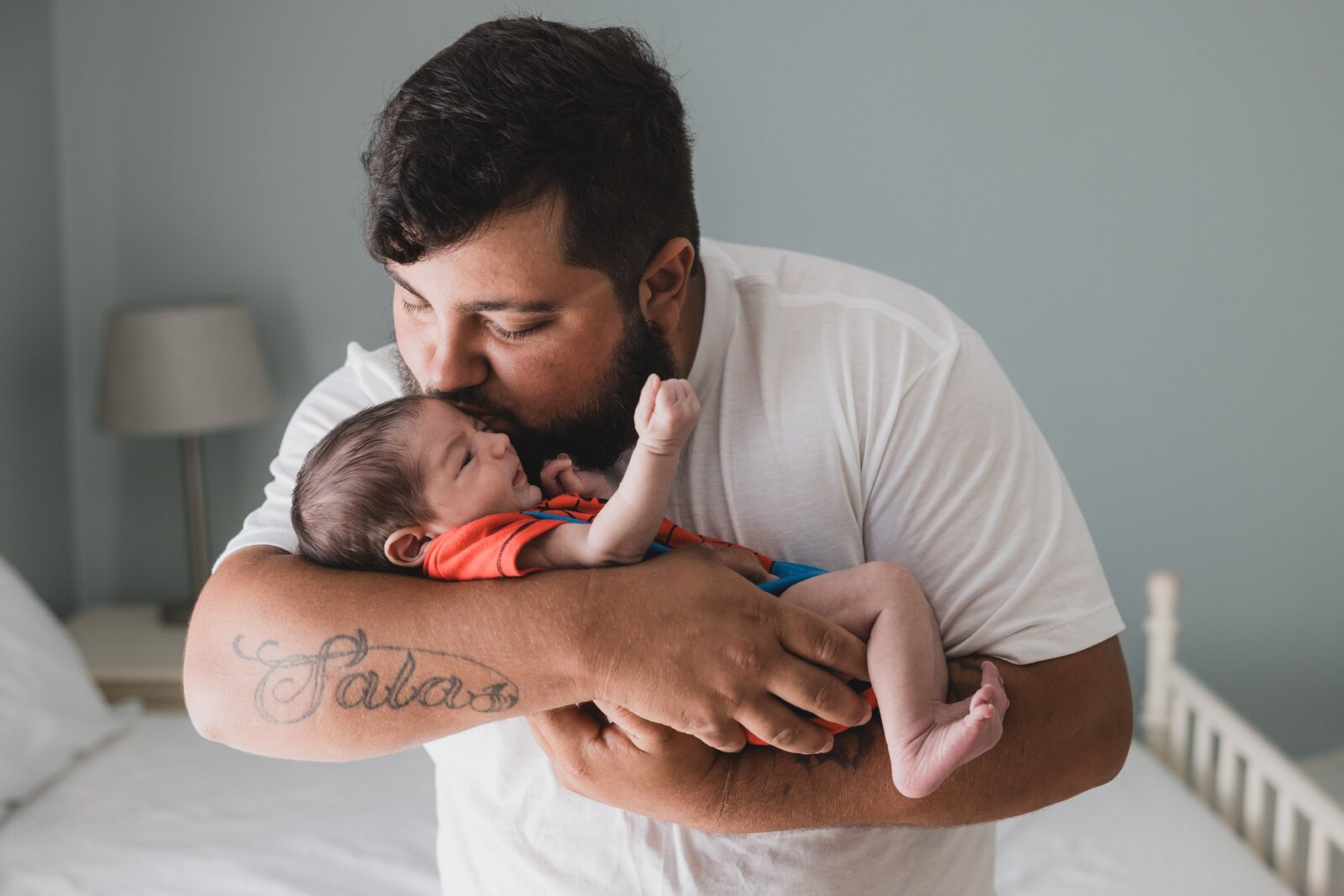 Father kissing newborn son during photo session by Jennifer Beal Phtography