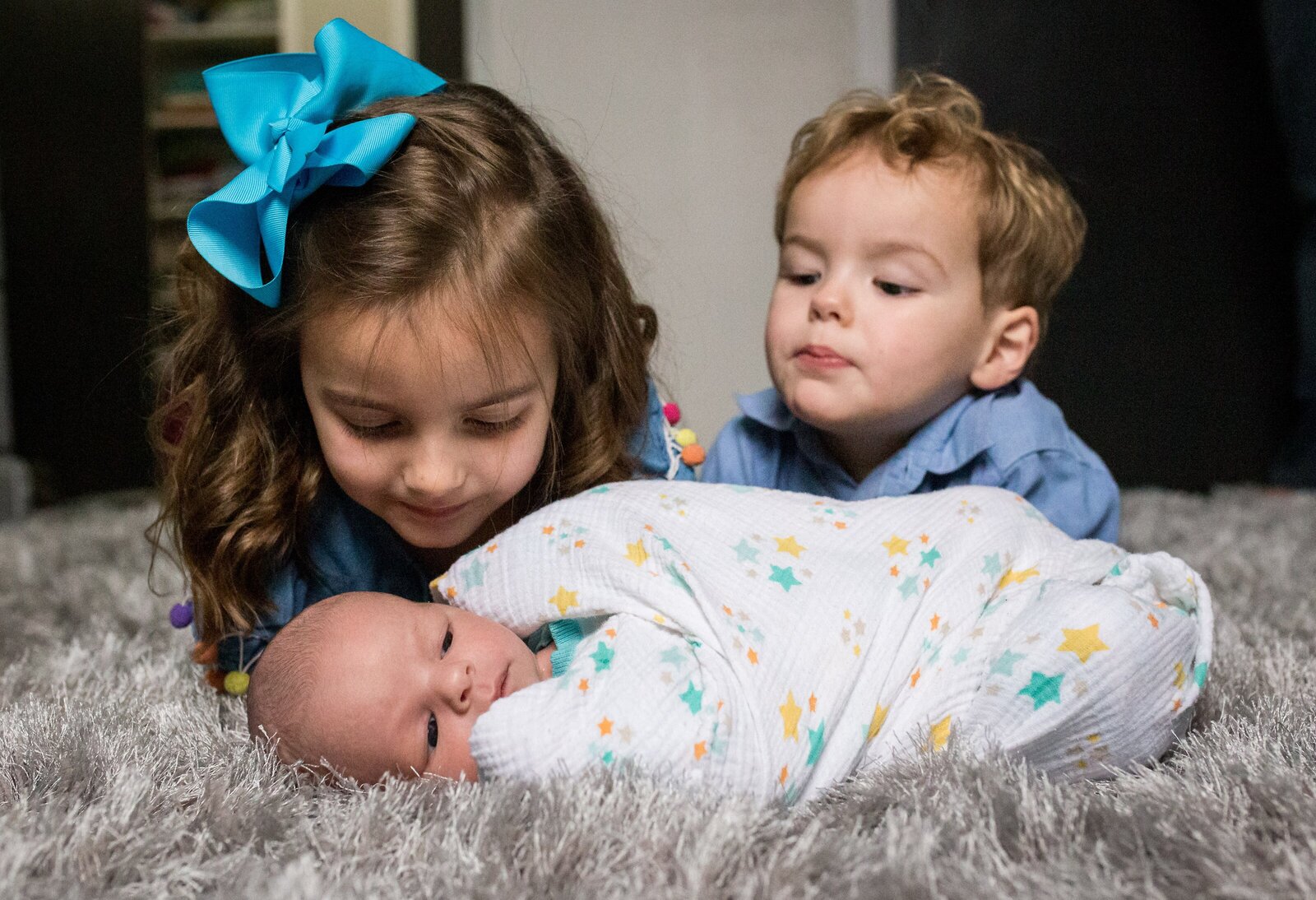siblings kissing newborn brother during family photo session
