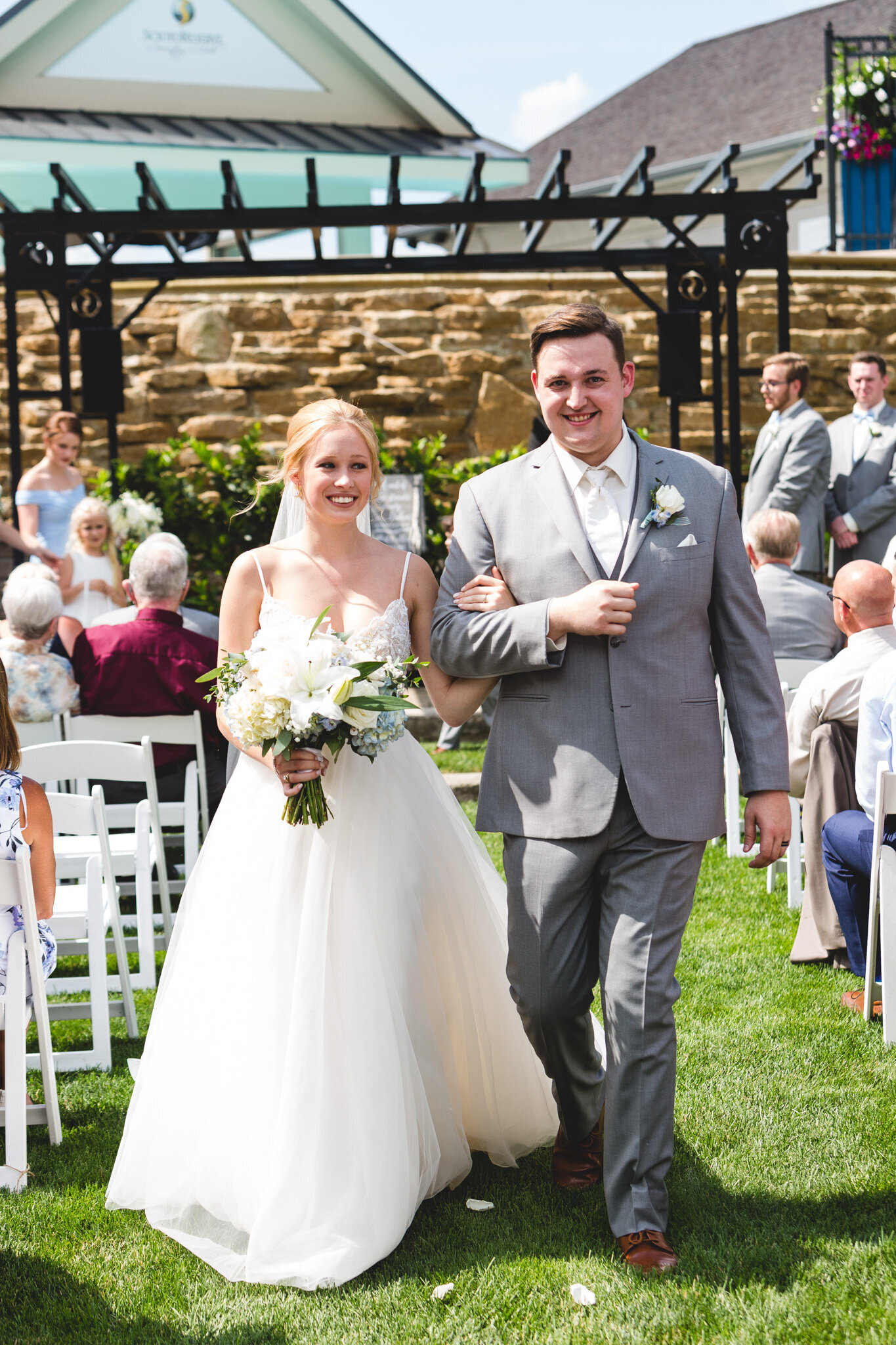 bride and groom recessional smiling with flowers ohio wedding