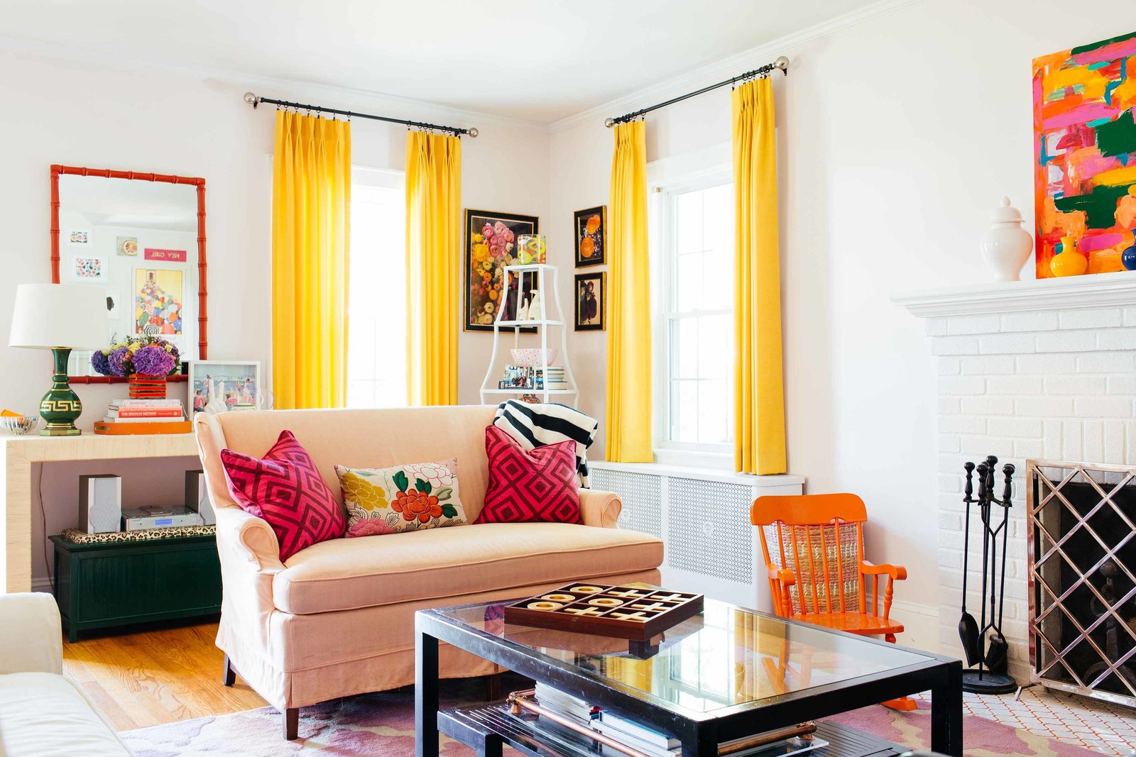 A peach love seat in a colorful living room.