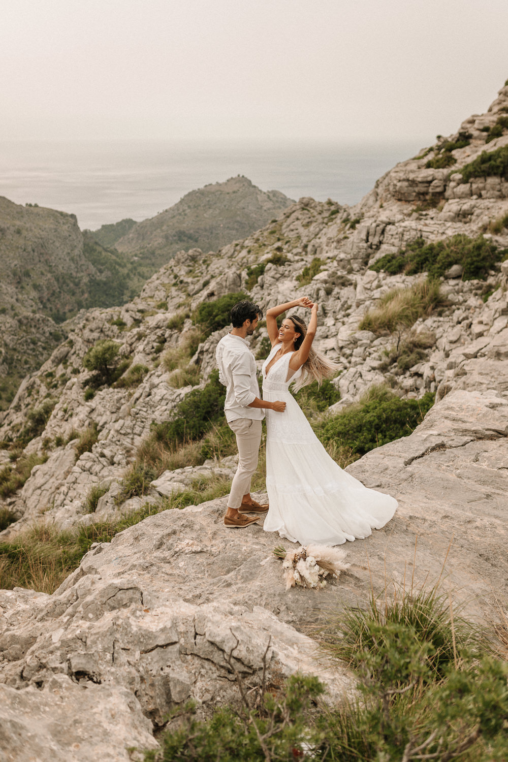 Brautpaar steht auf einem Felsen in dem Tramuntana Gebirge auf Mallorca