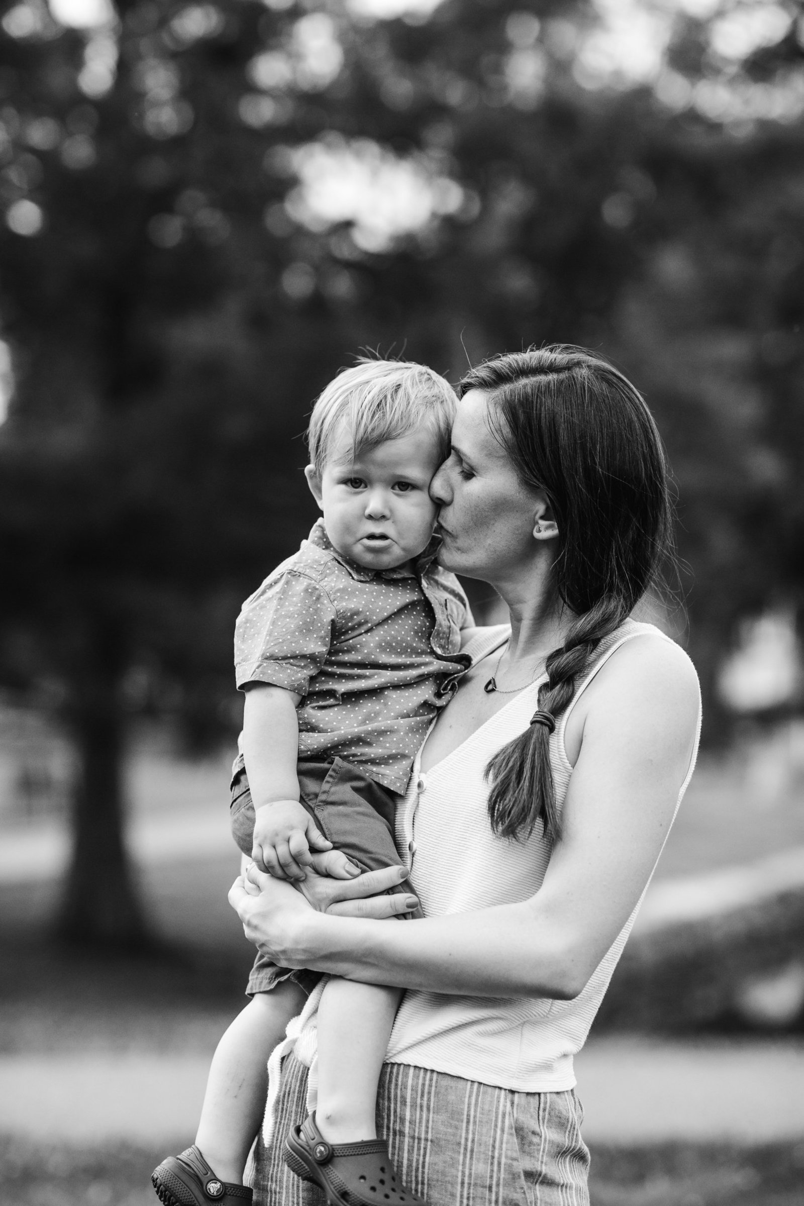 black and white portrait of mother holding toddler son who is crying in boston ma