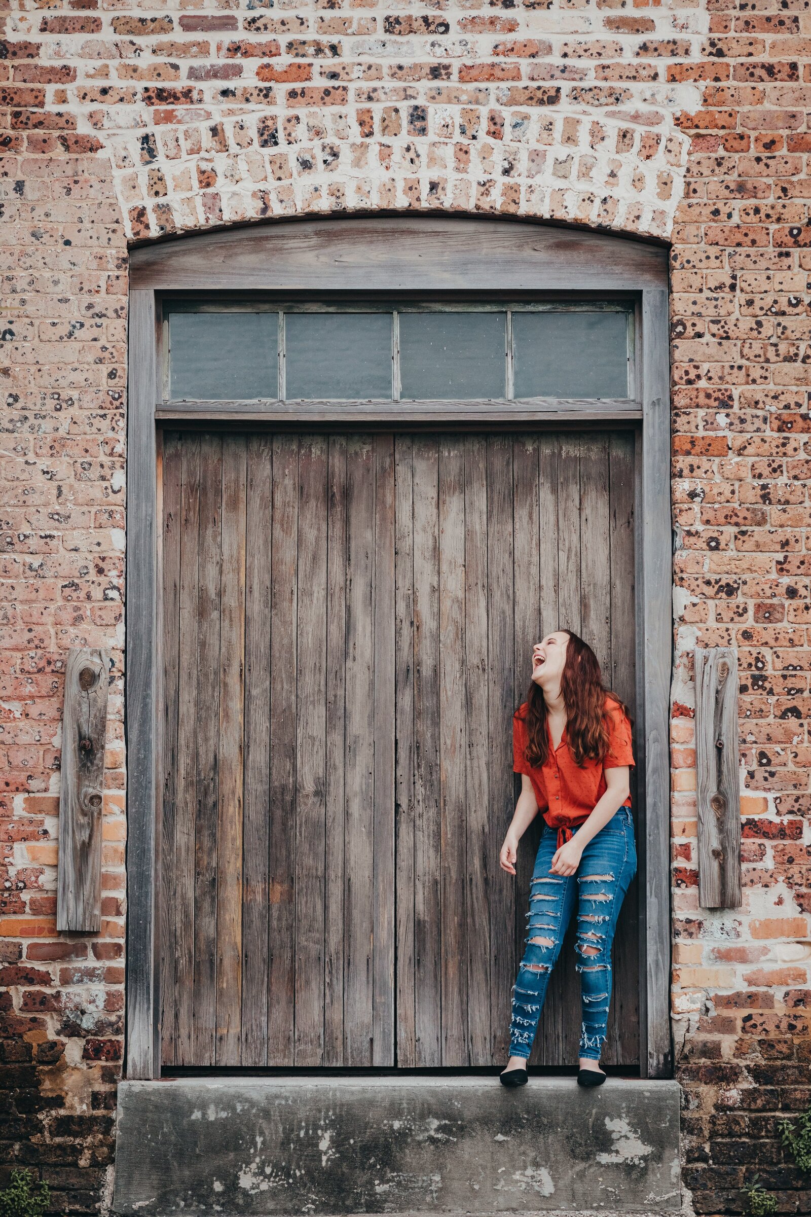 Senior portrait session in downtown pensacola with senior girl laughing.