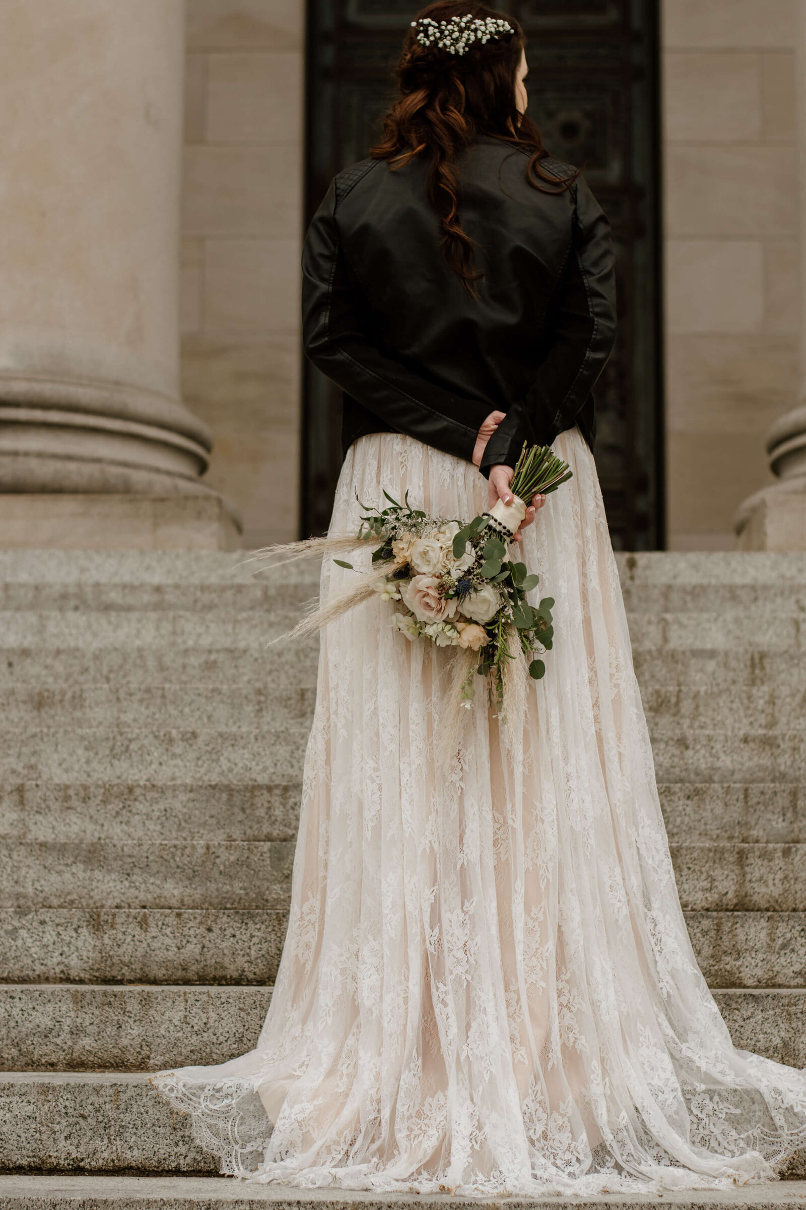 Bride wears leather jacket with wedding dress.