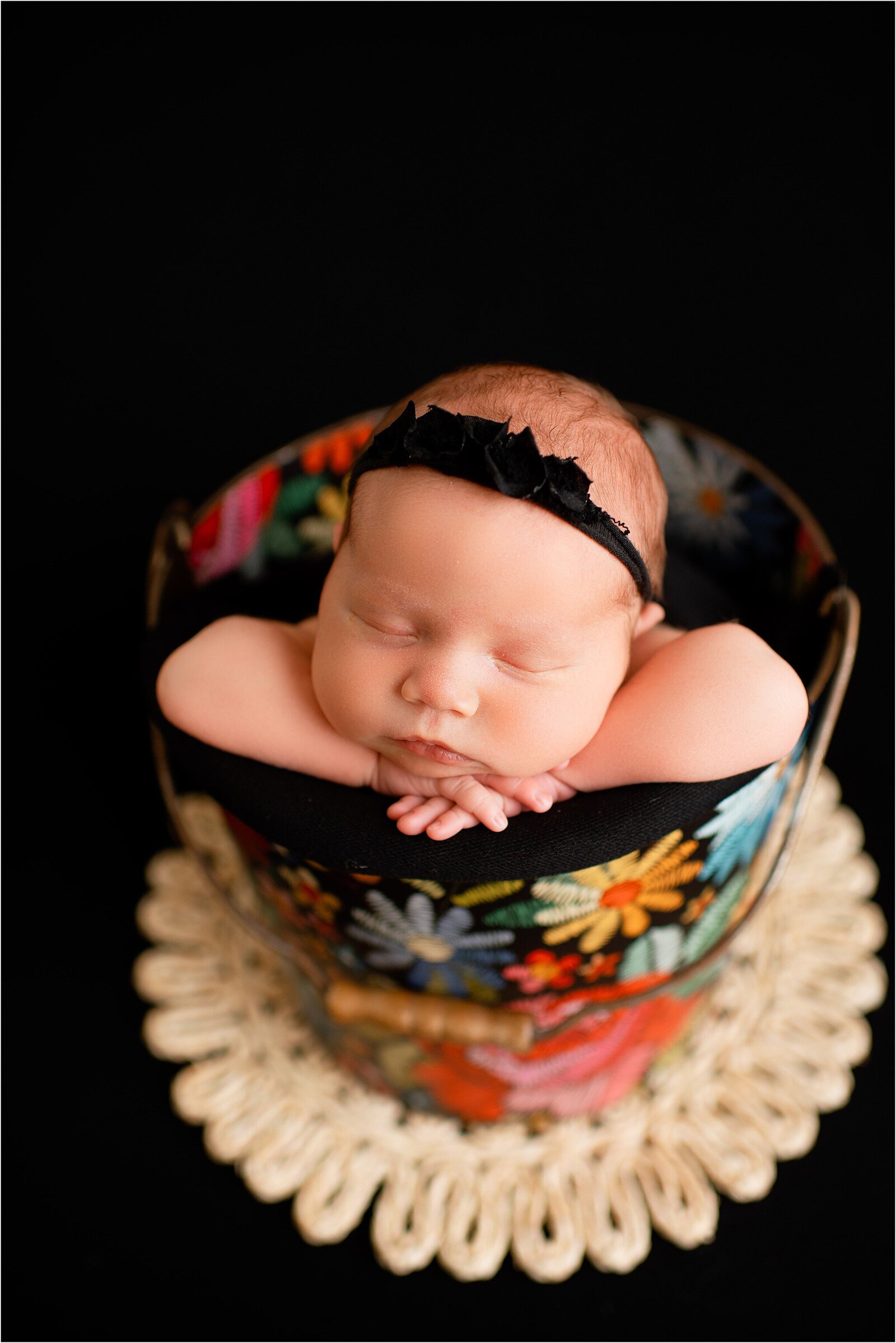 newborn in colorful floral bucket