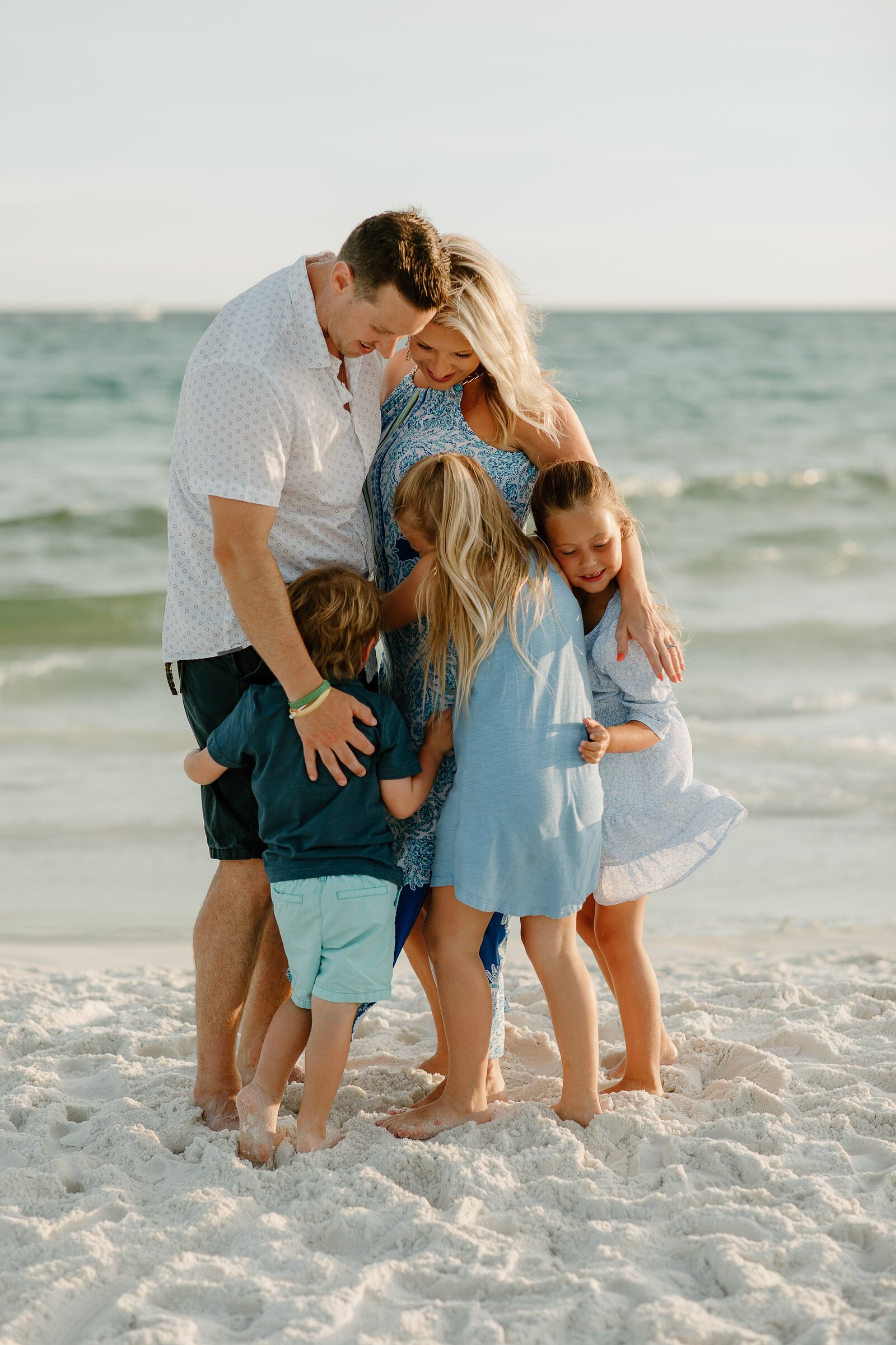 Pensacola Beach vacation family photography session .  Family  group hug on the beach.