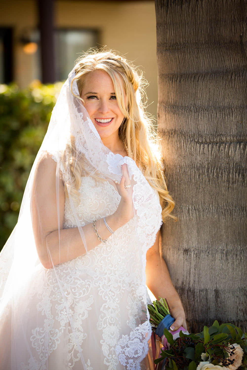 bride smiling with veil over shoulder