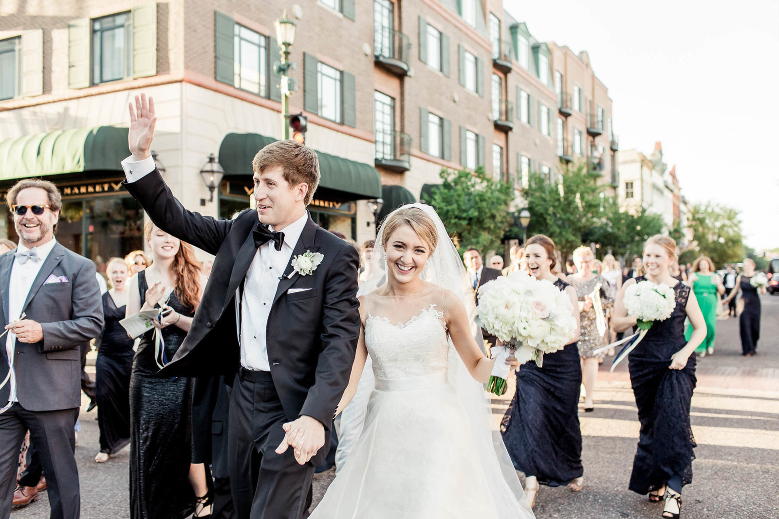 Bride and groom march down King Street with Burke high school marching band, Charleston, South Carolina. Kate Timbers Photography.