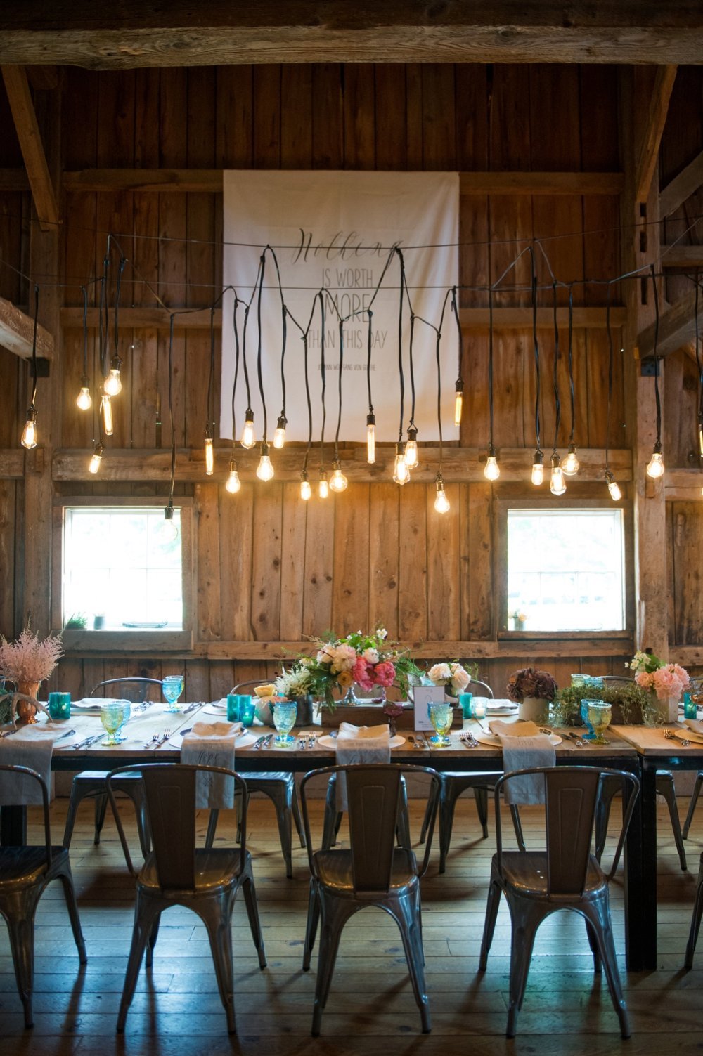Gorgeous rustic tablescape for barn wedding with Edison Bulb light installation