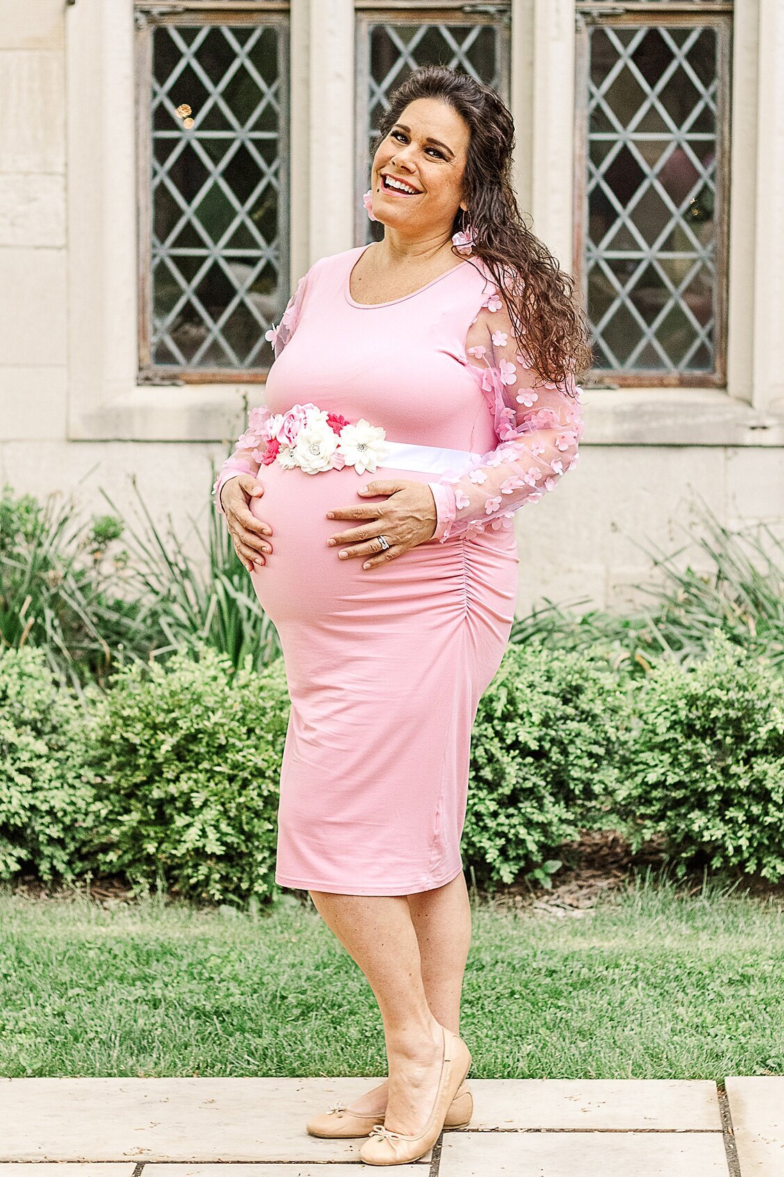 Beautiful mama to be standing and holding her belly during her outdoor maternity session in Wexford PA