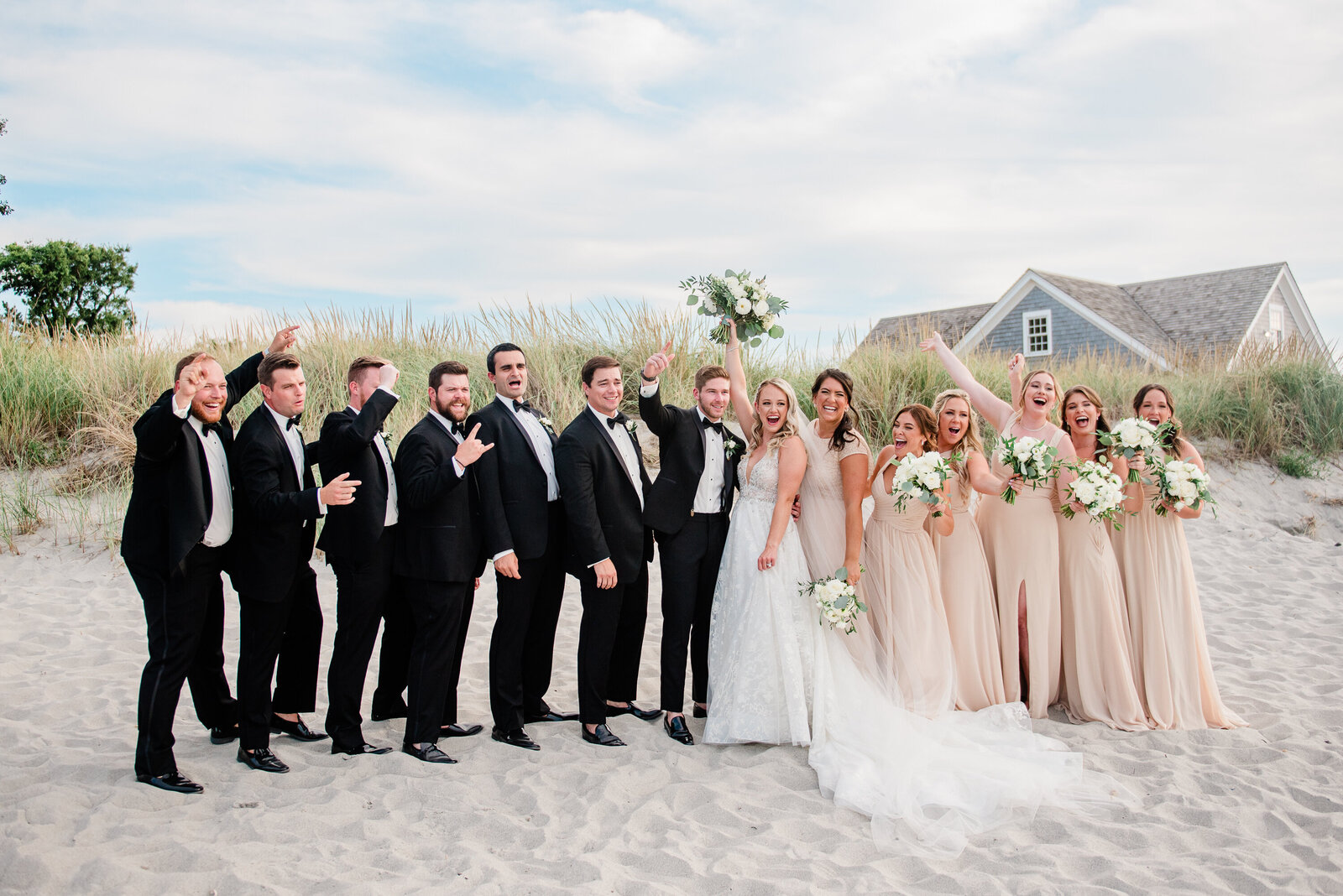 bridal party at a wedding on the beach cheering