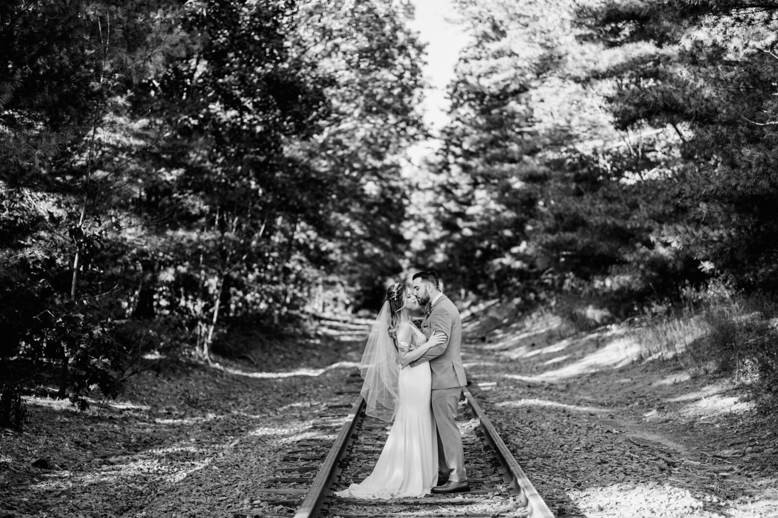 couple kissing on railroad