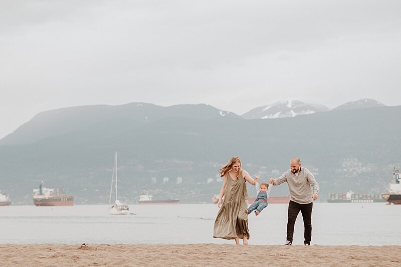 Mom and dad swinging little boy at Jericho Beach by Vancouver Family Photographer