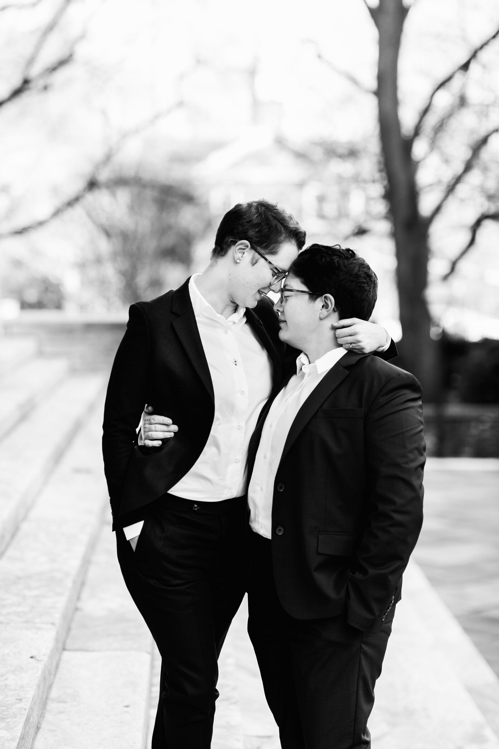 gay brides in suits at marble steps