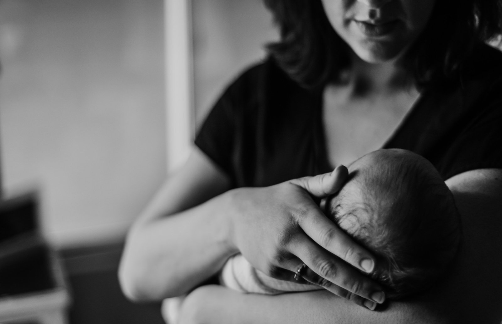 rootedandwildphotography_bremerton_mom_holding_newborn_black_and_white_detail