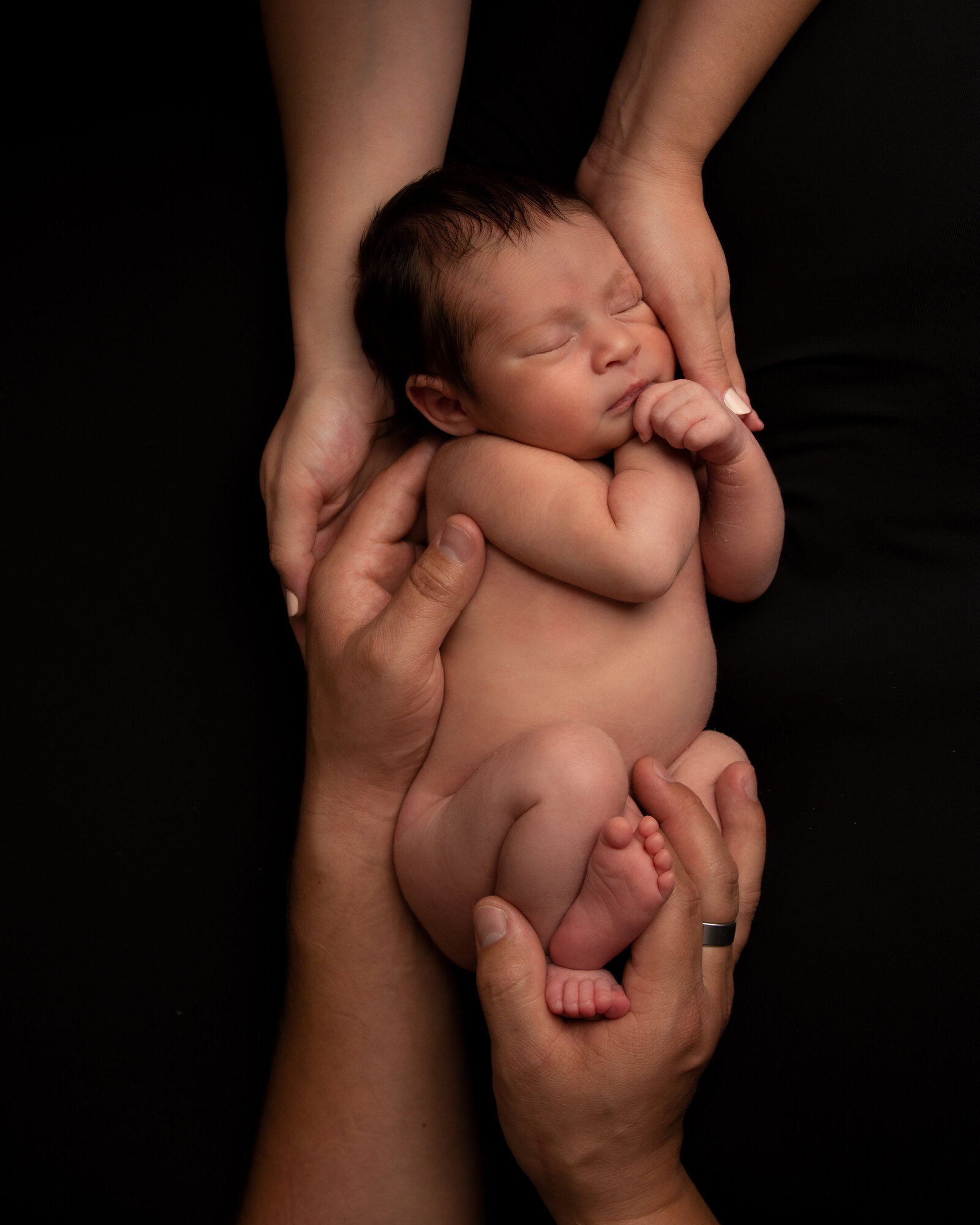 Baby girl sleeping in her parents hands