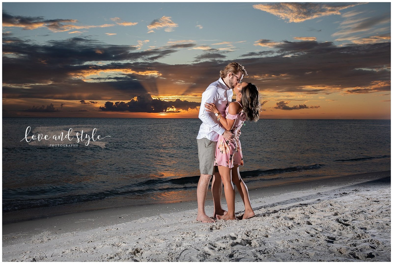 Couple newly engaged kissing on  Anna Maria island Beach at sunset