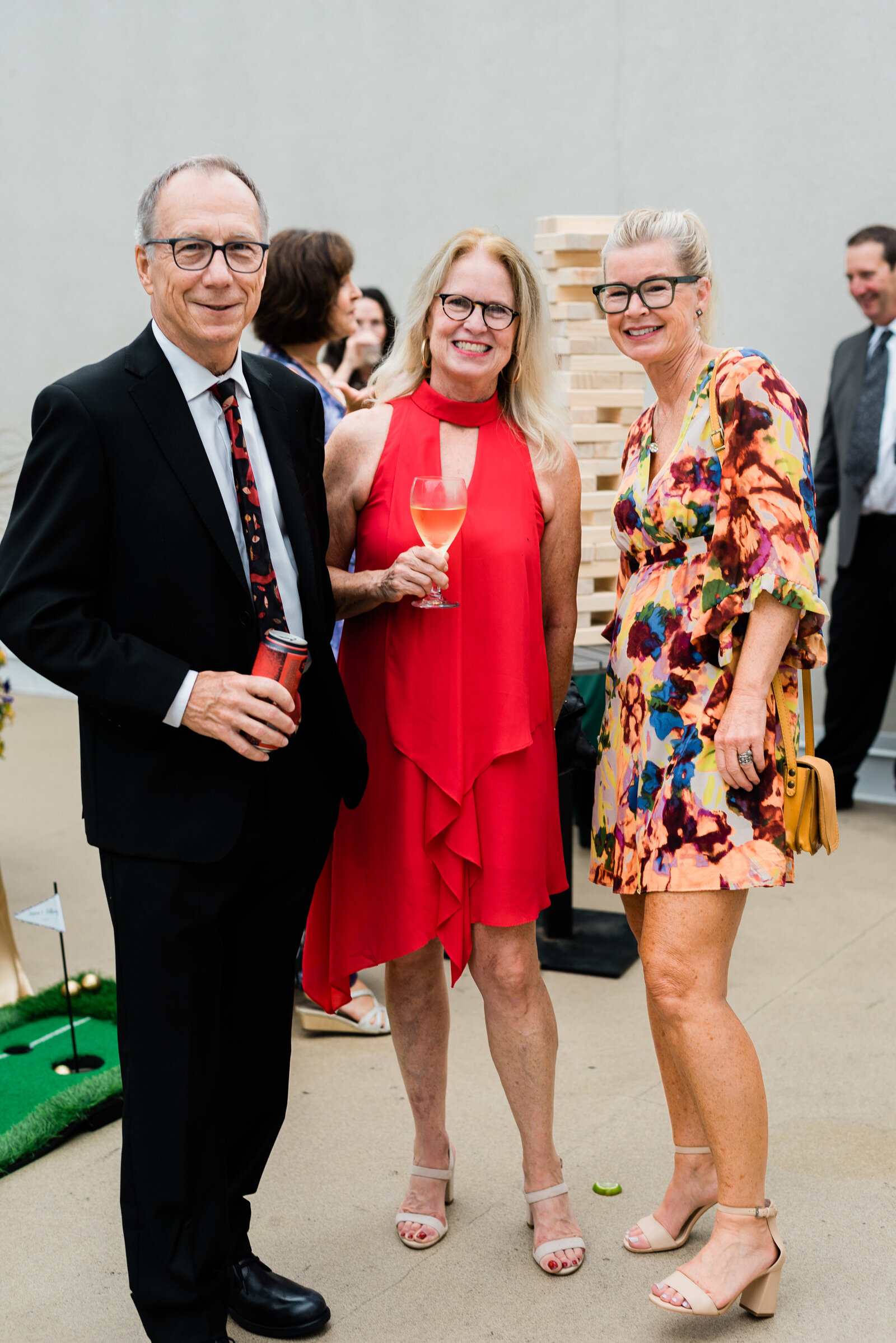 Three wedding guests standing and smiling at the camera