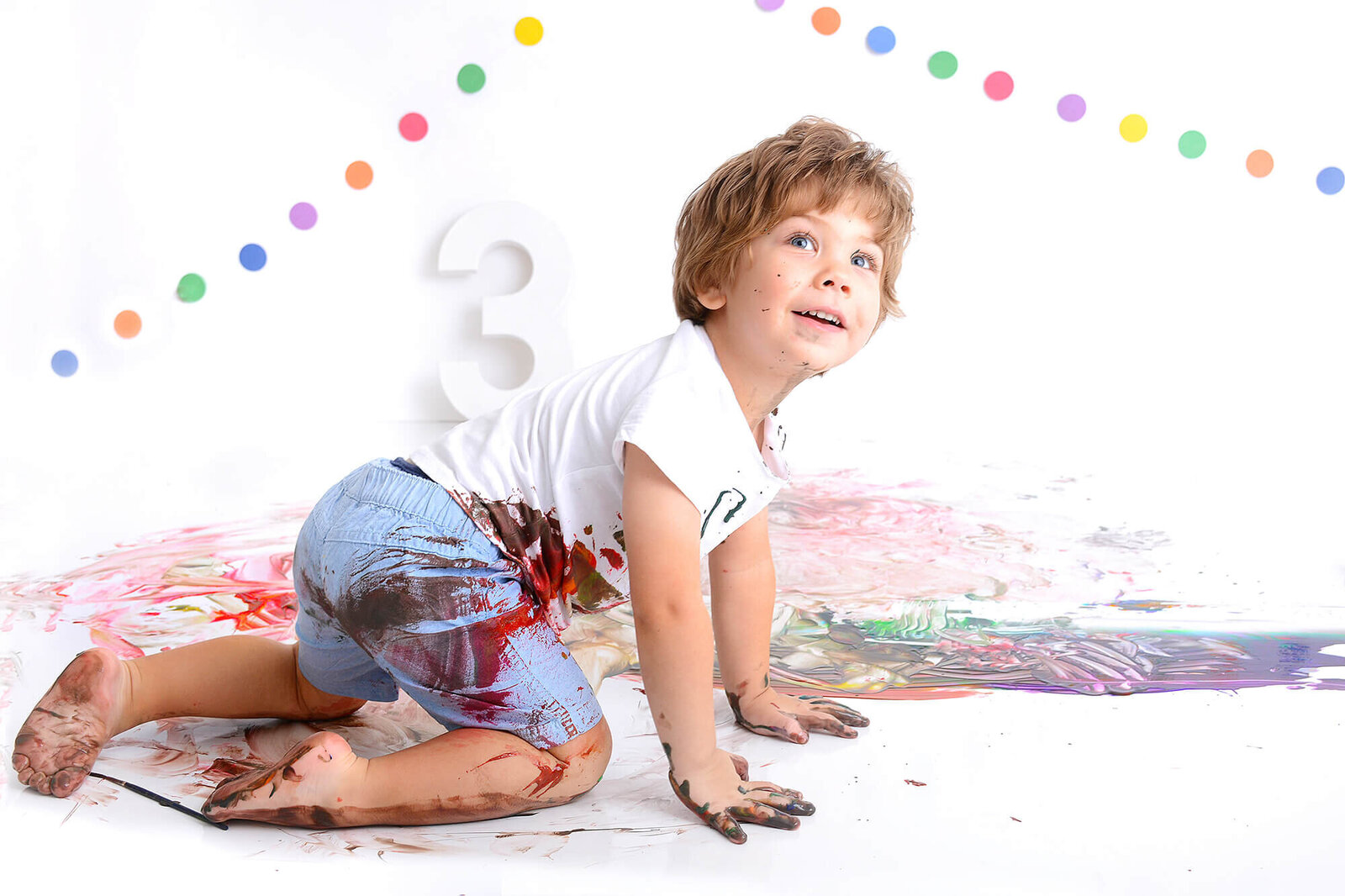 boy smiles at his paint photoshoot in houston
