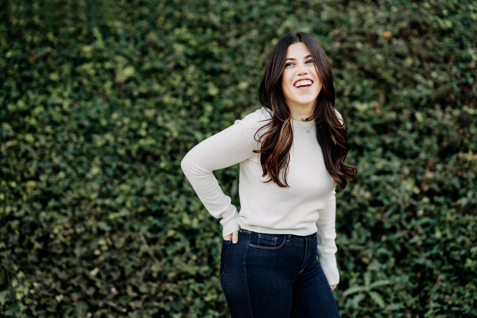 woman laughing at ivy wall