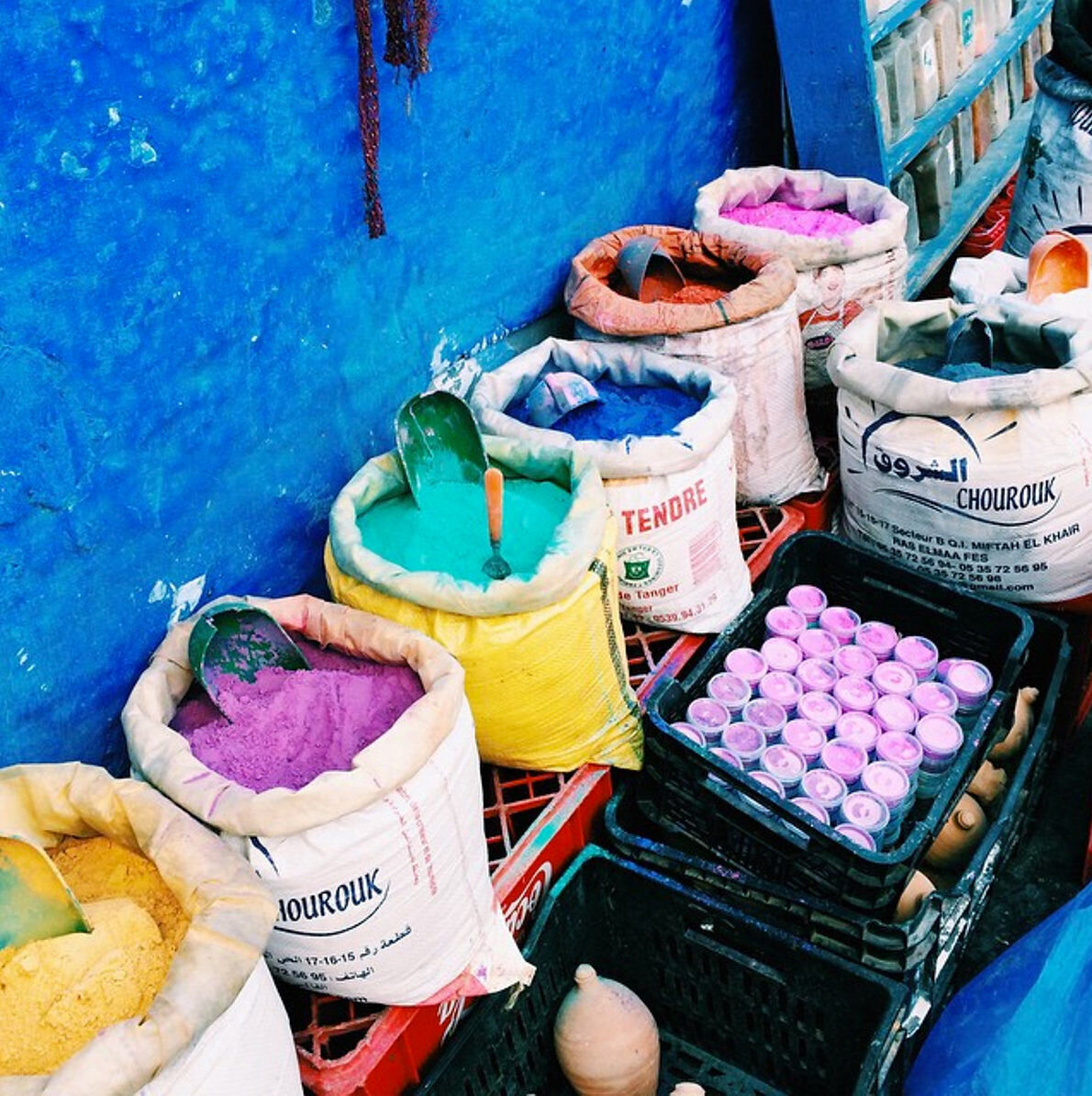 Travel photographer Chelsea Loren capturing blue city of Chefchaouen, Morocco colorful paint pigments in bags