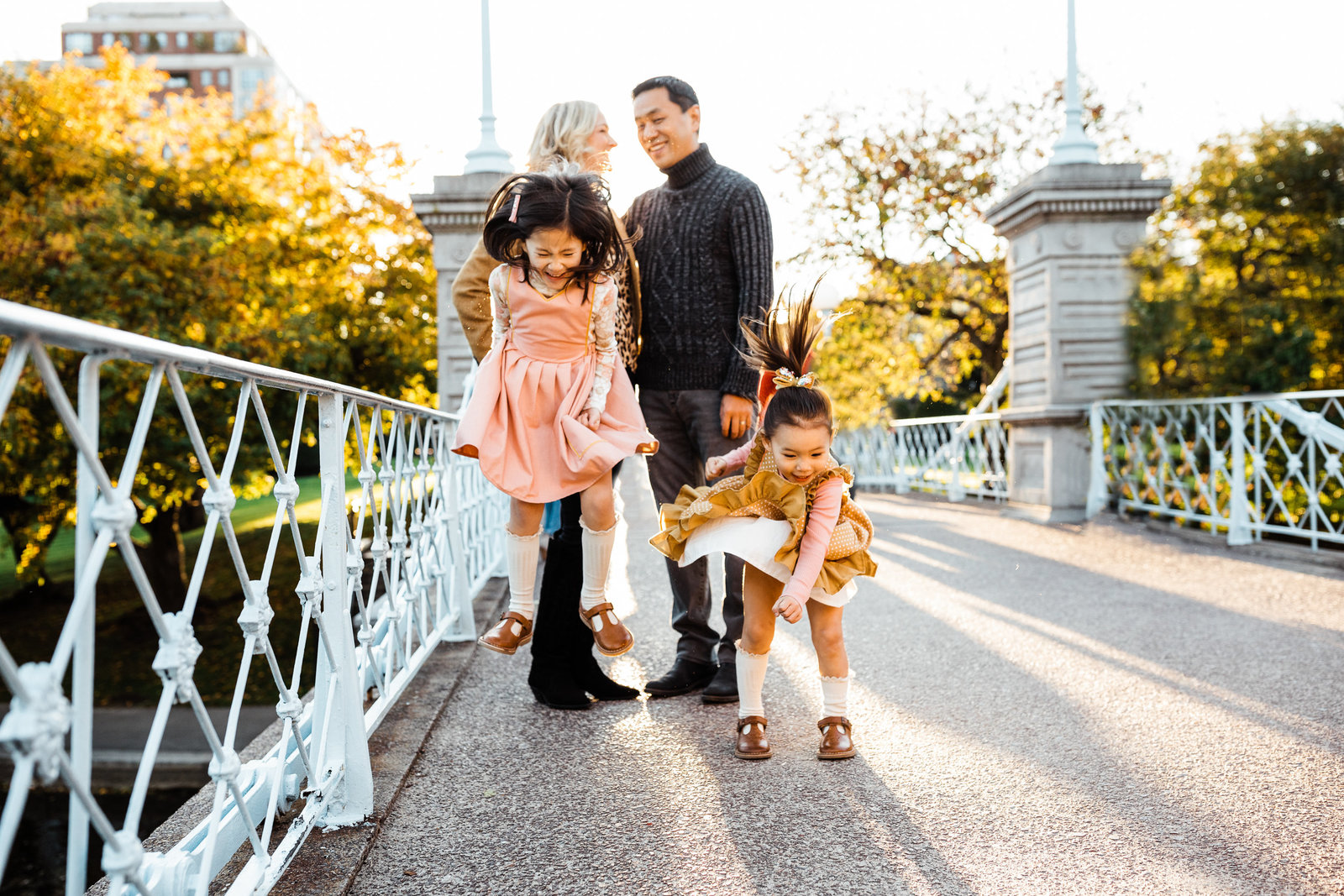 two sisters jump on a bridge in boston public garden family session