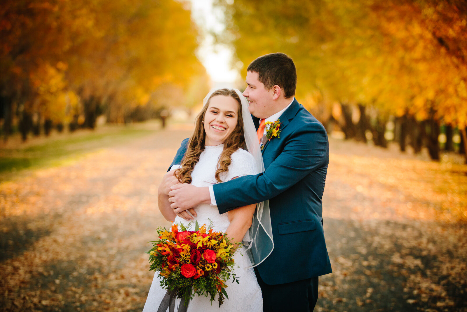 groom holding bride and hugging her during fall portraits