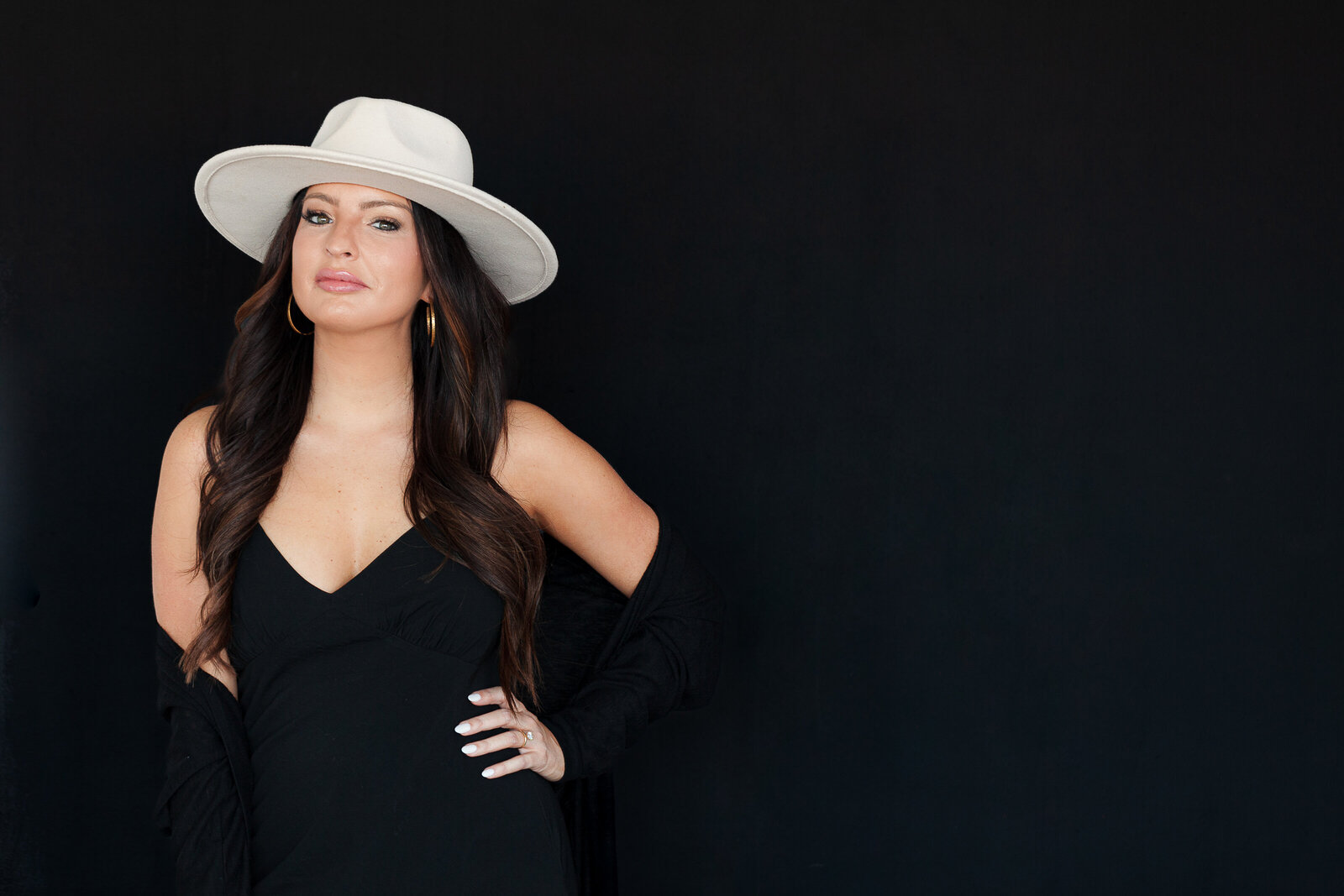 woman-headshot-black-dress-black-background-wearing-hat-the-frame-charlotte