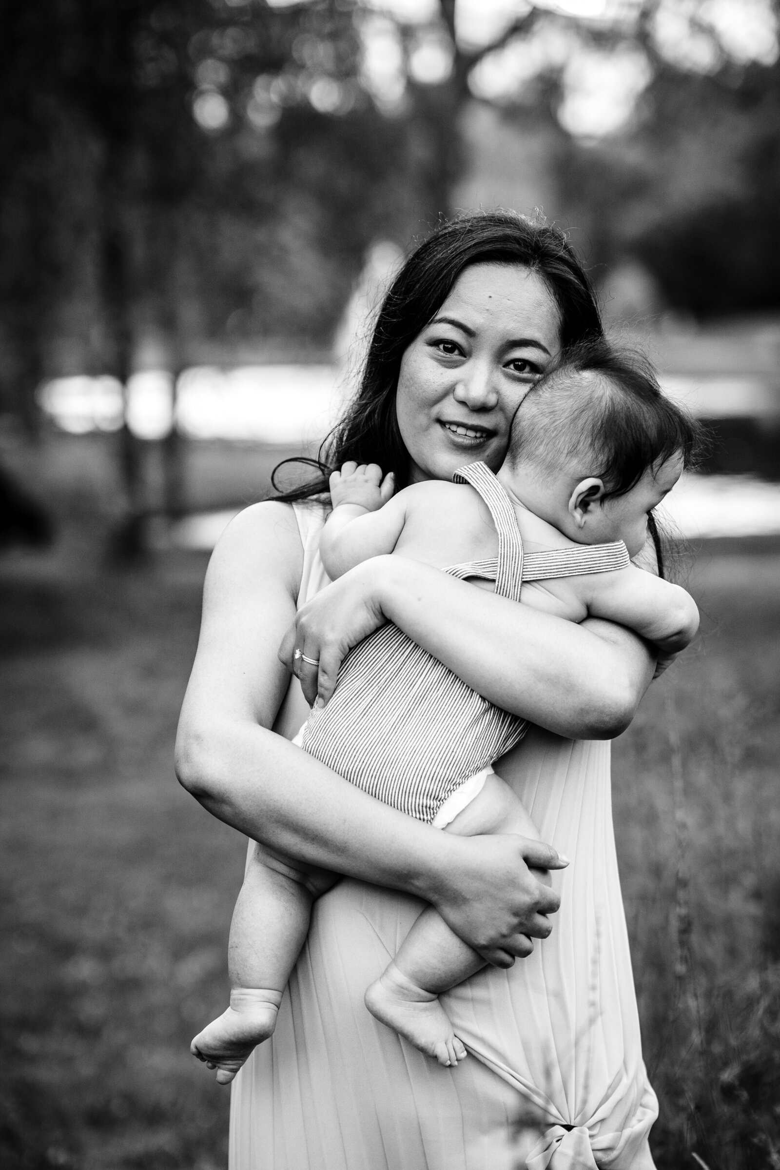 black and white image of mother holding son to chest