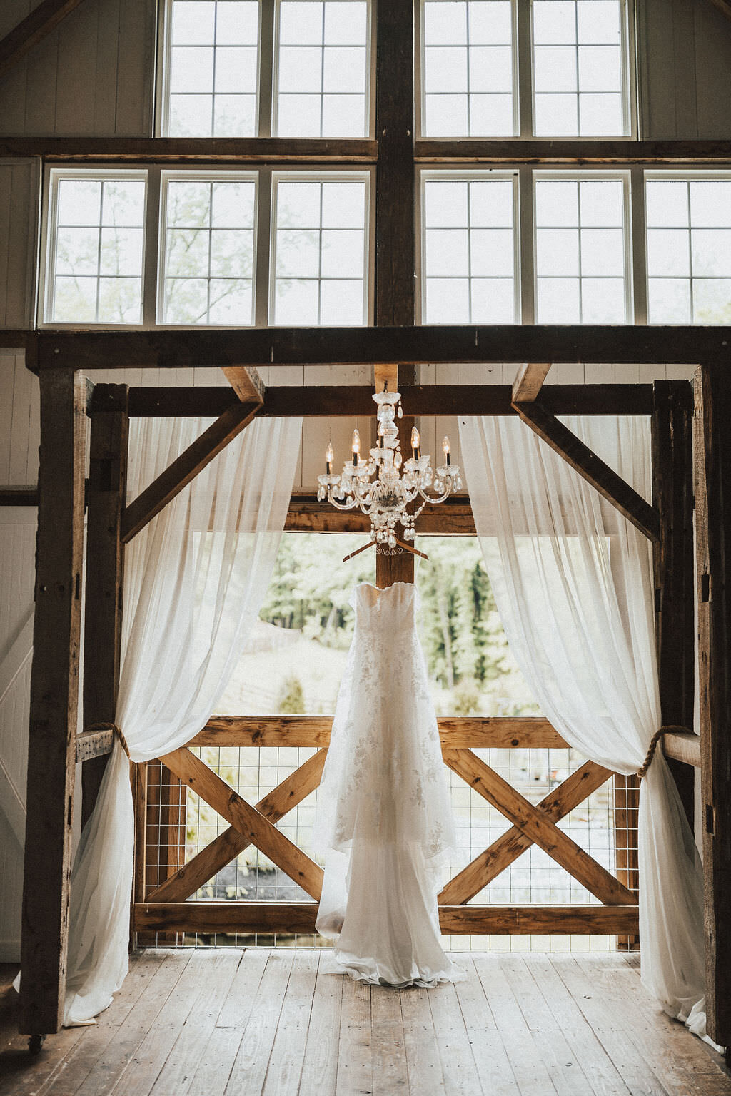 wedding dress hanging from wooden arch
