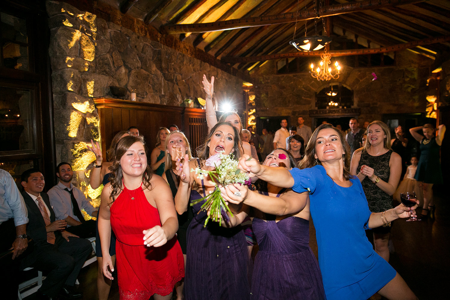friends catching bouquet at reception
