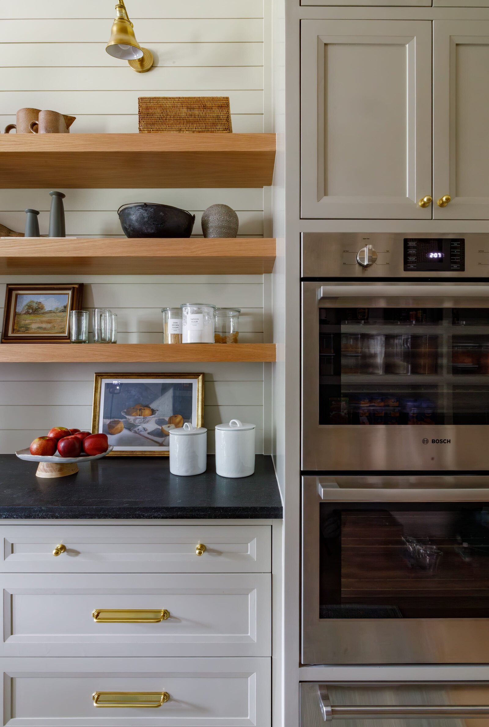 vision and hammer oven and wooden floating shelves and dark countertop