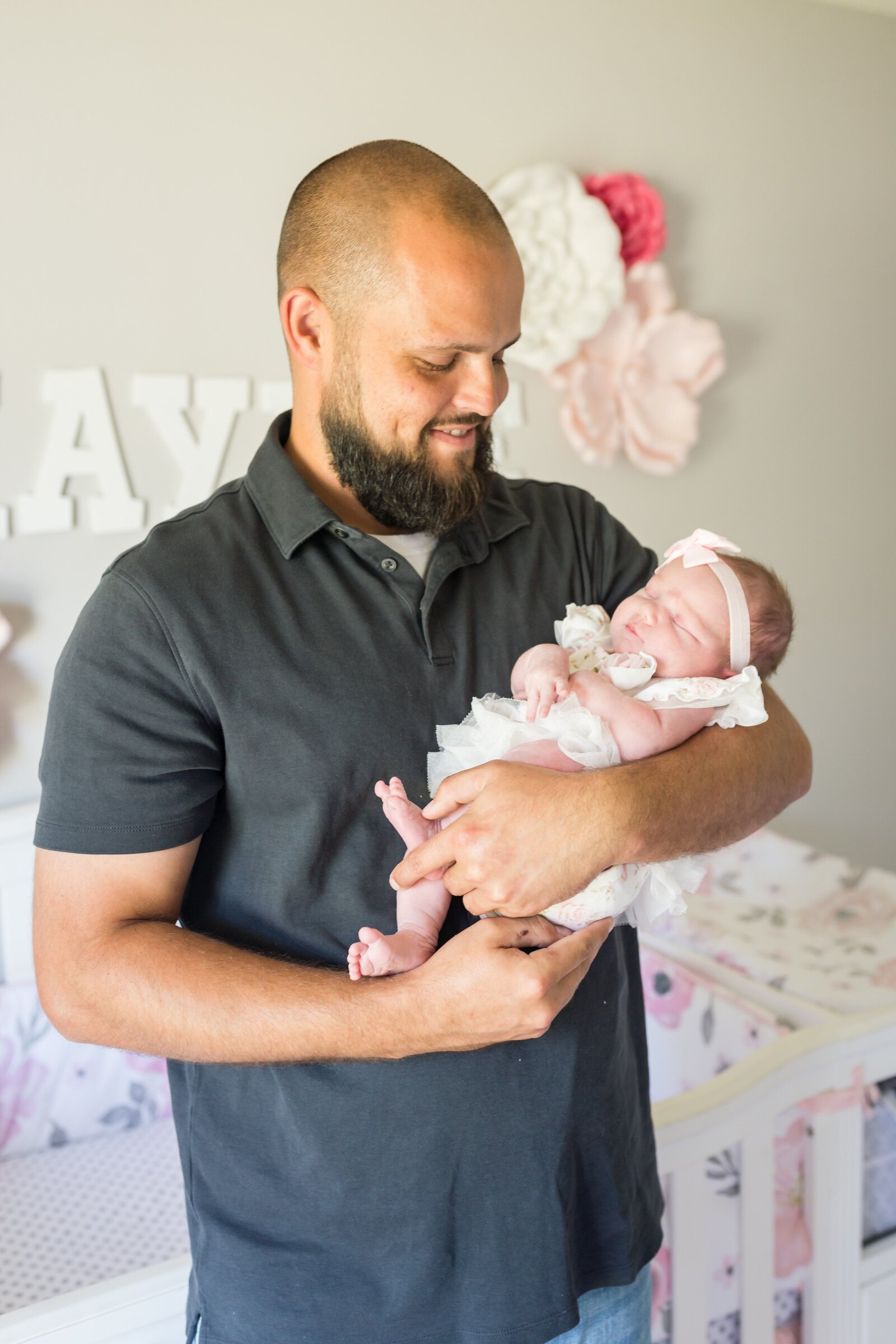 Daddy holding newborn daughter in-home newborn  photo session