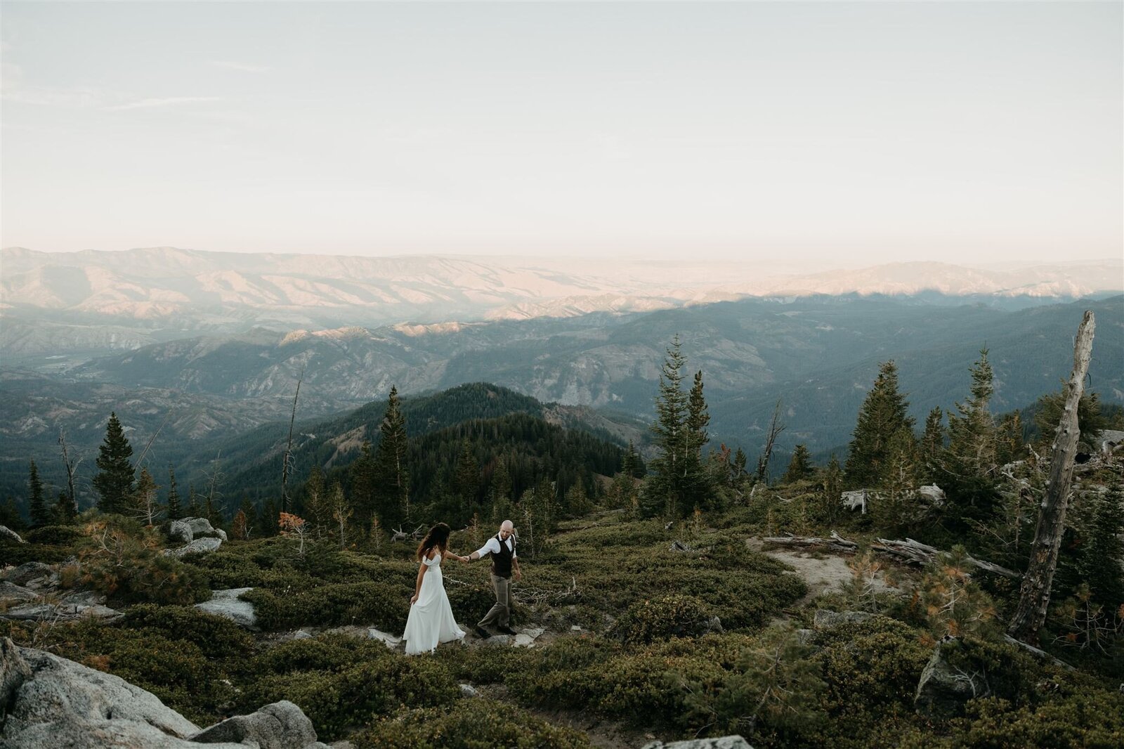 Adventurous candid elopement couple holding hands and overlooking the view of the Enchantments Cascade Mountain Range in Washington