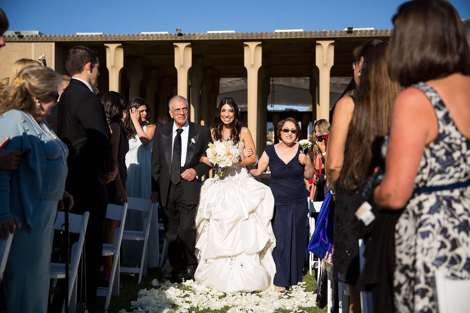 A beautiful Persian bride makes her way down the aisle with her parents