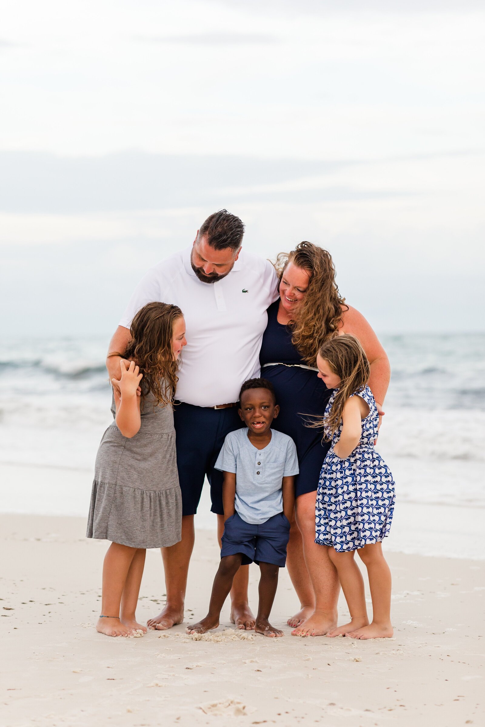 Family of 5 embracing during photo session on Pensacola Beach