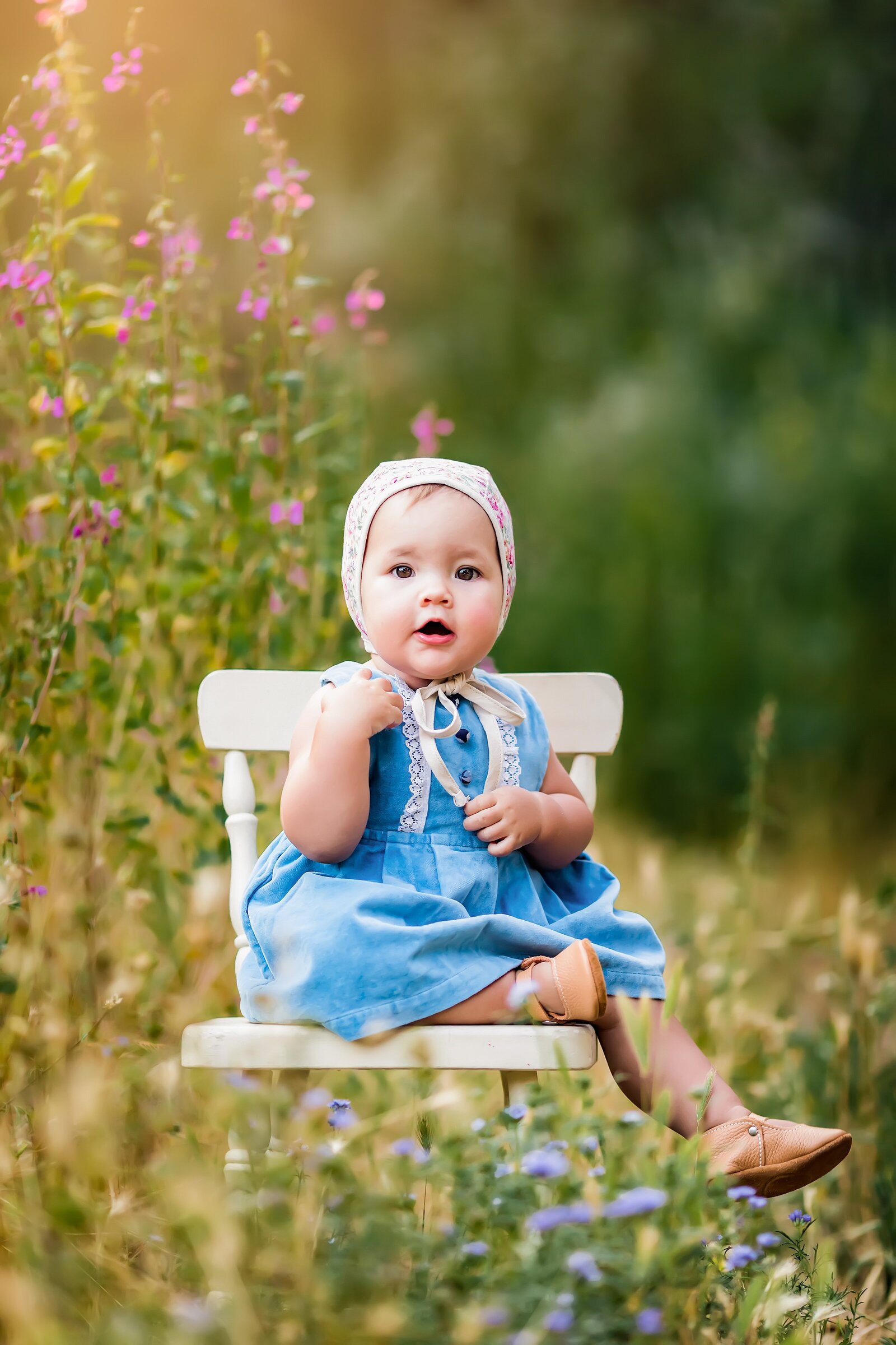 Baby girl sitting on a white chair among wildflowers in Escondido