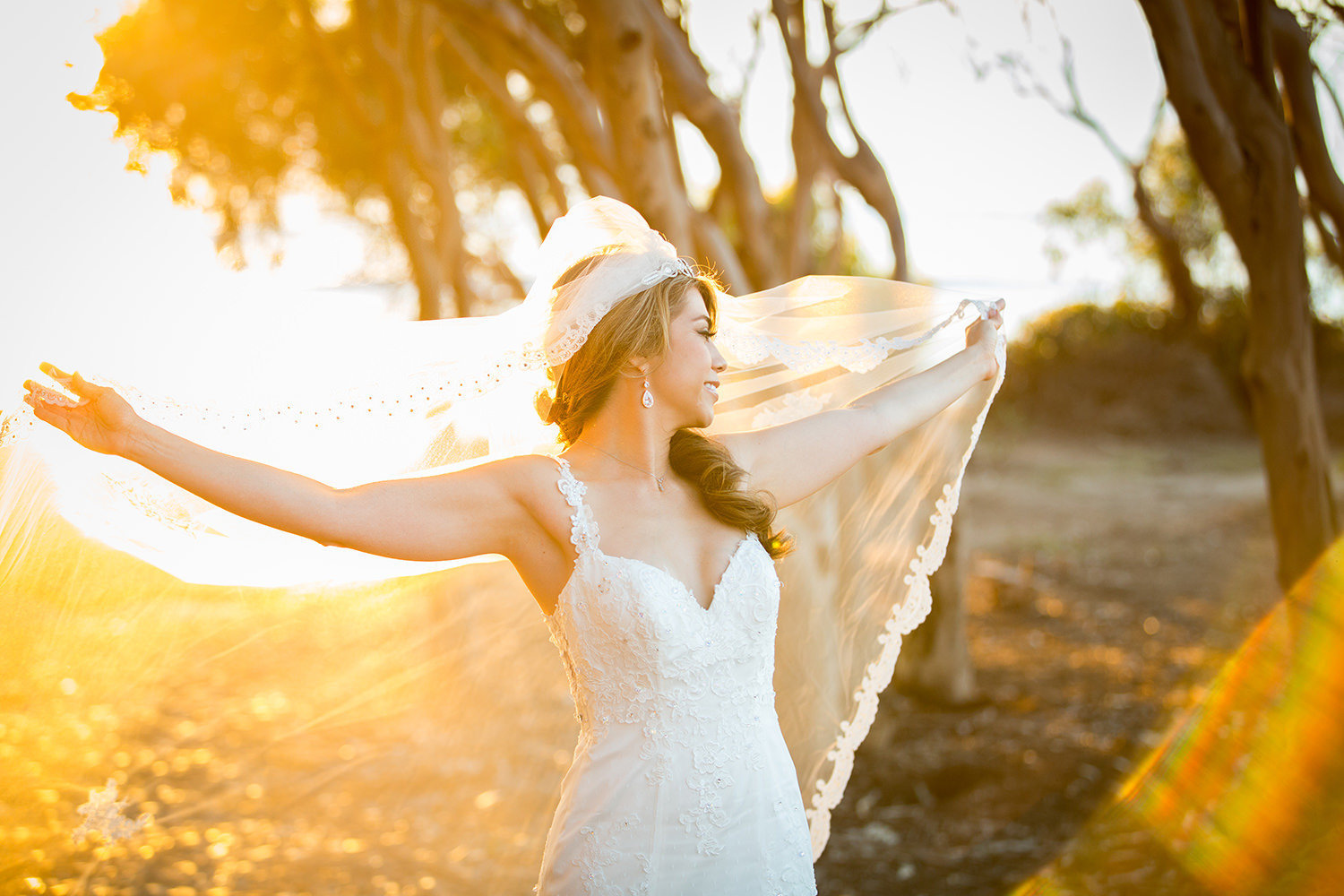 bride with long veil at sunset cliffs