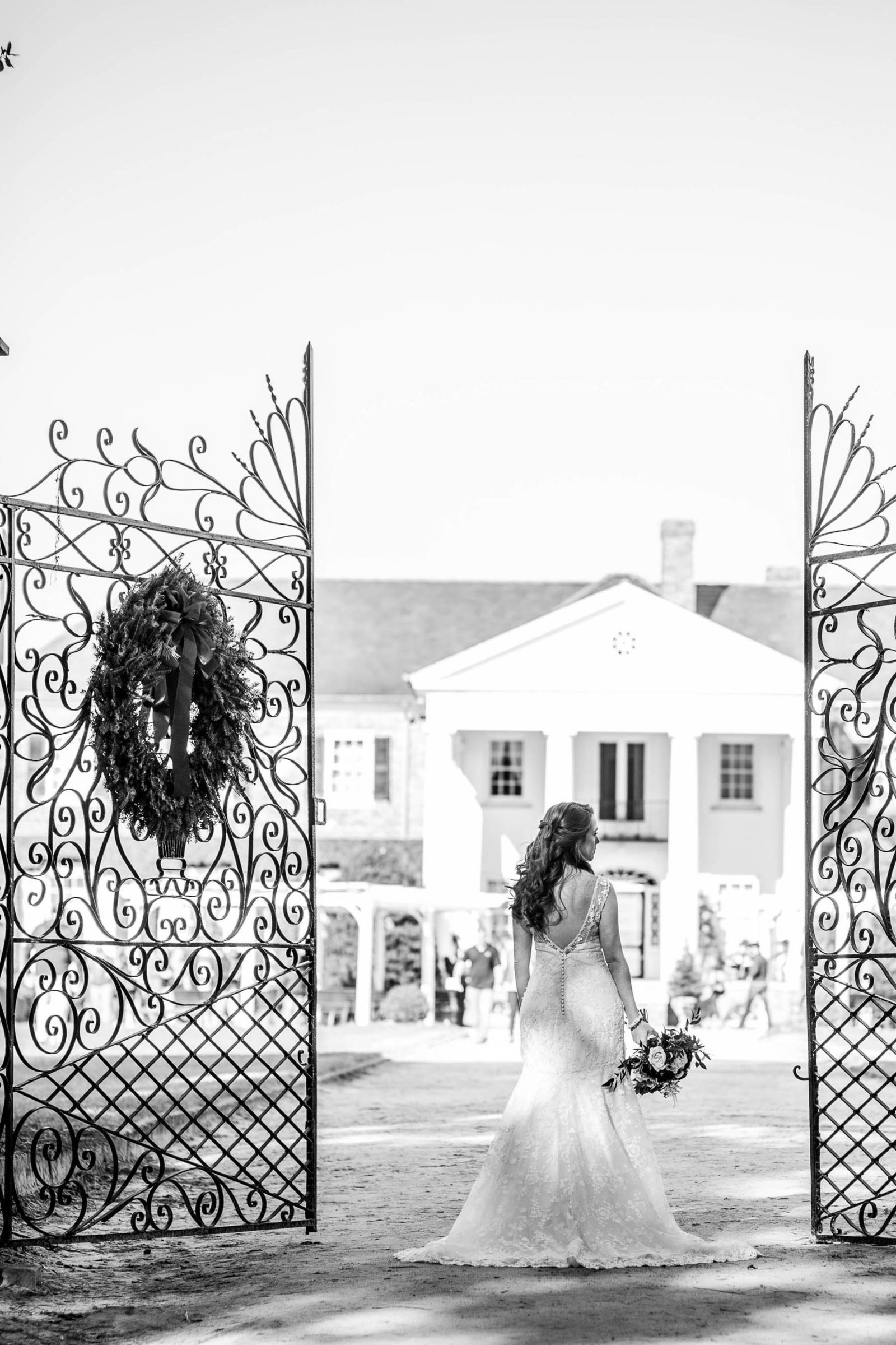 Bride stands by gate of estate, Boone Hall Plantation, Charleston, South Carolina