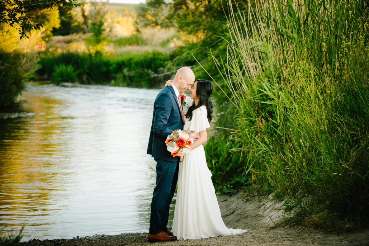 bride and groom kissing waterside after jackson hole wedding