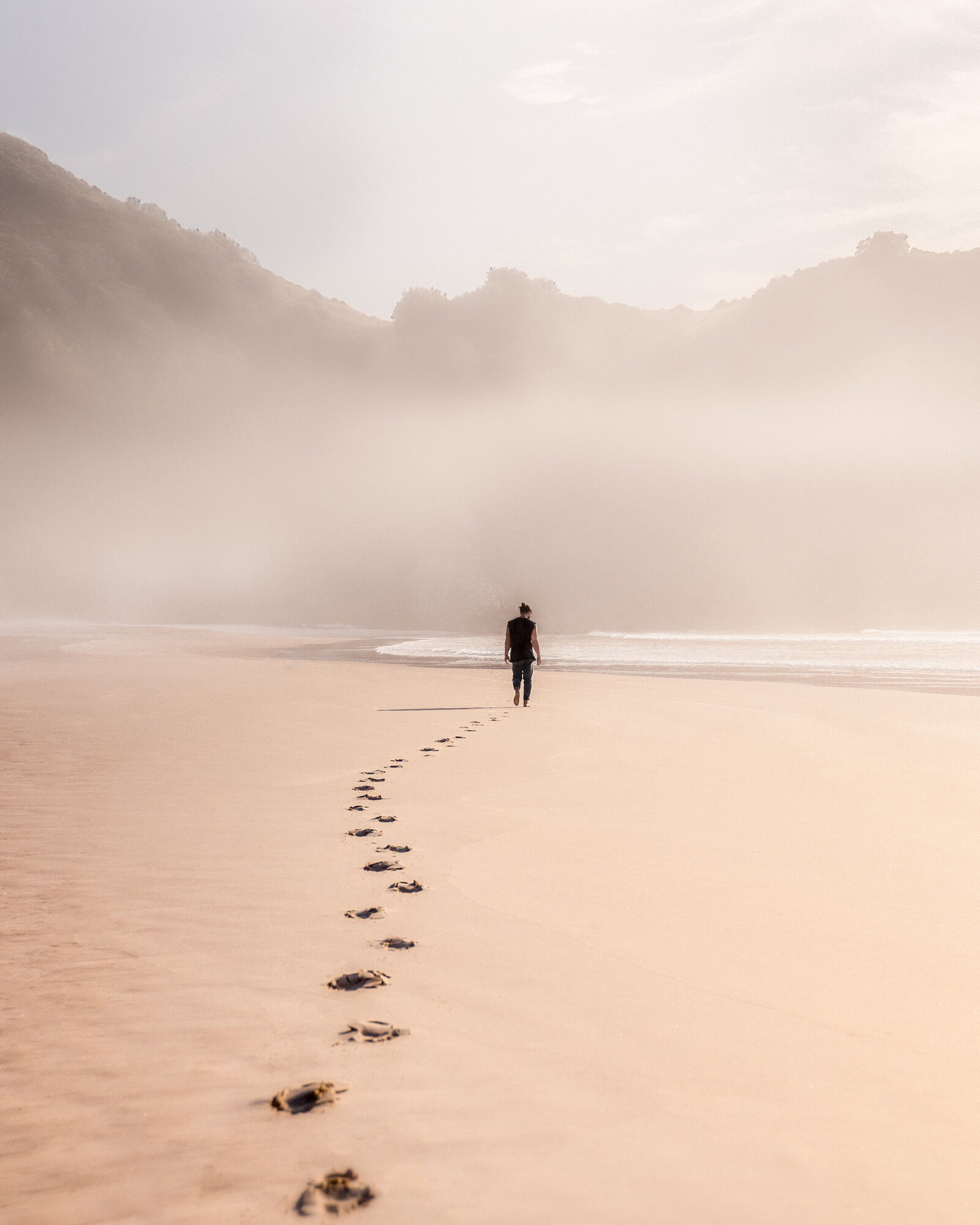 Man walking on beach towards the ocean
