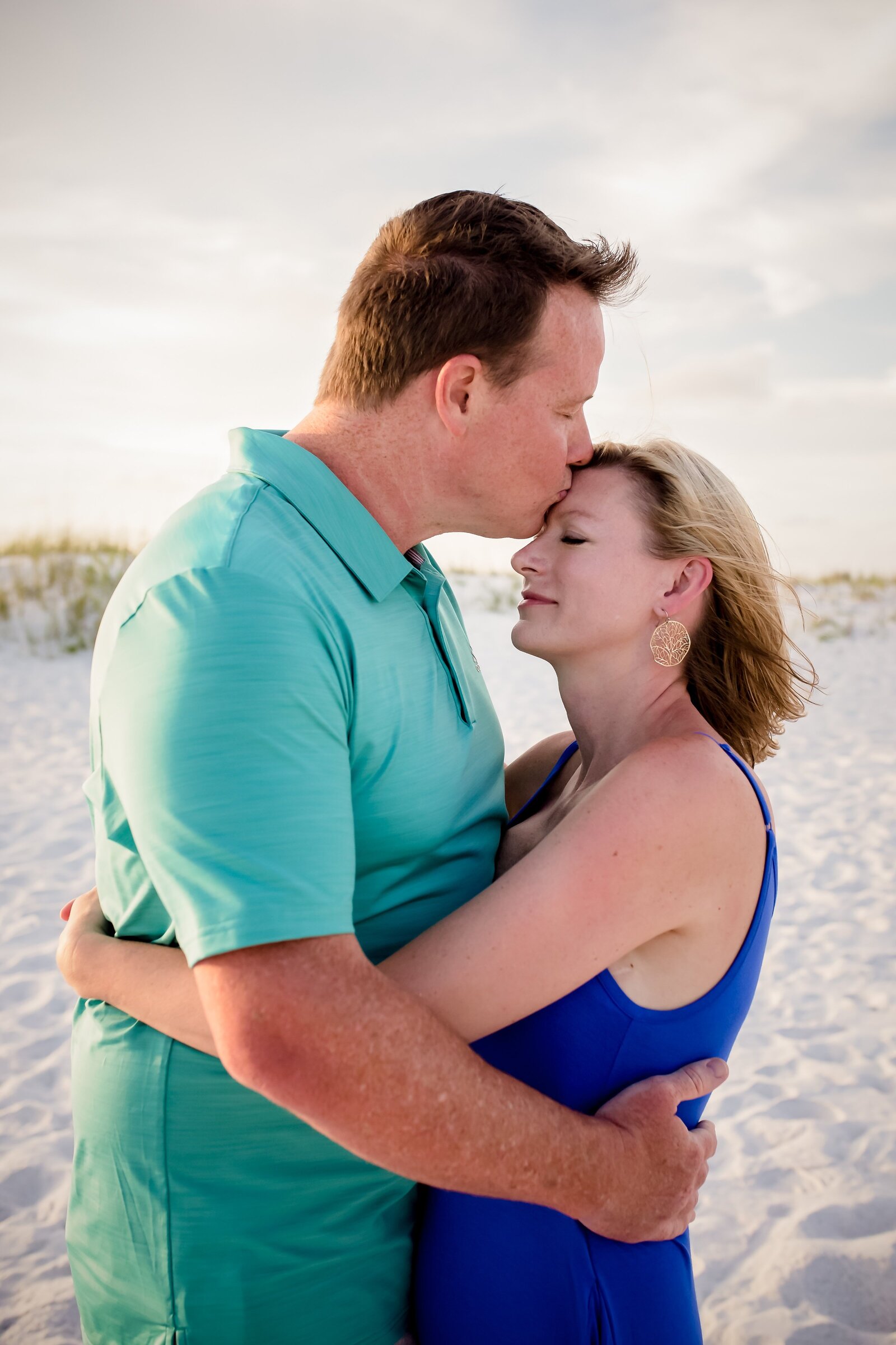 Pensacola Photography session during family vacation on Pensacola Beach . Husband and wife hugging each other at sunset.