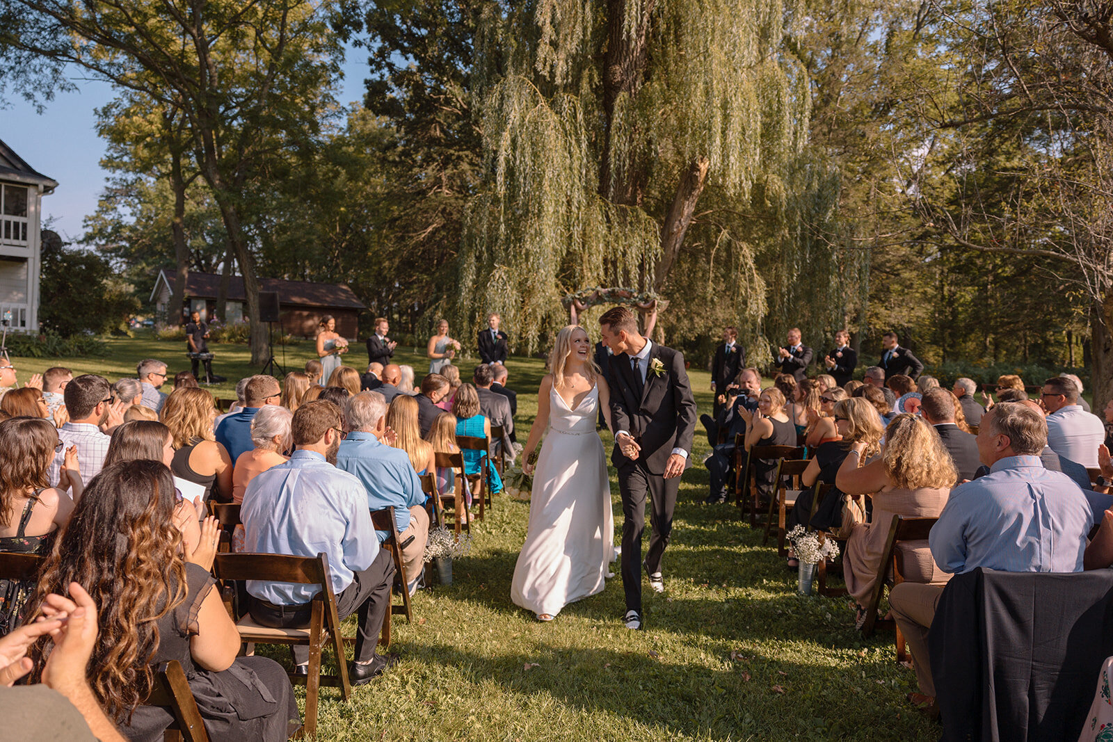 outdoor wedding ceremony under rhe willow tree at barnwood events in madison, winconsin