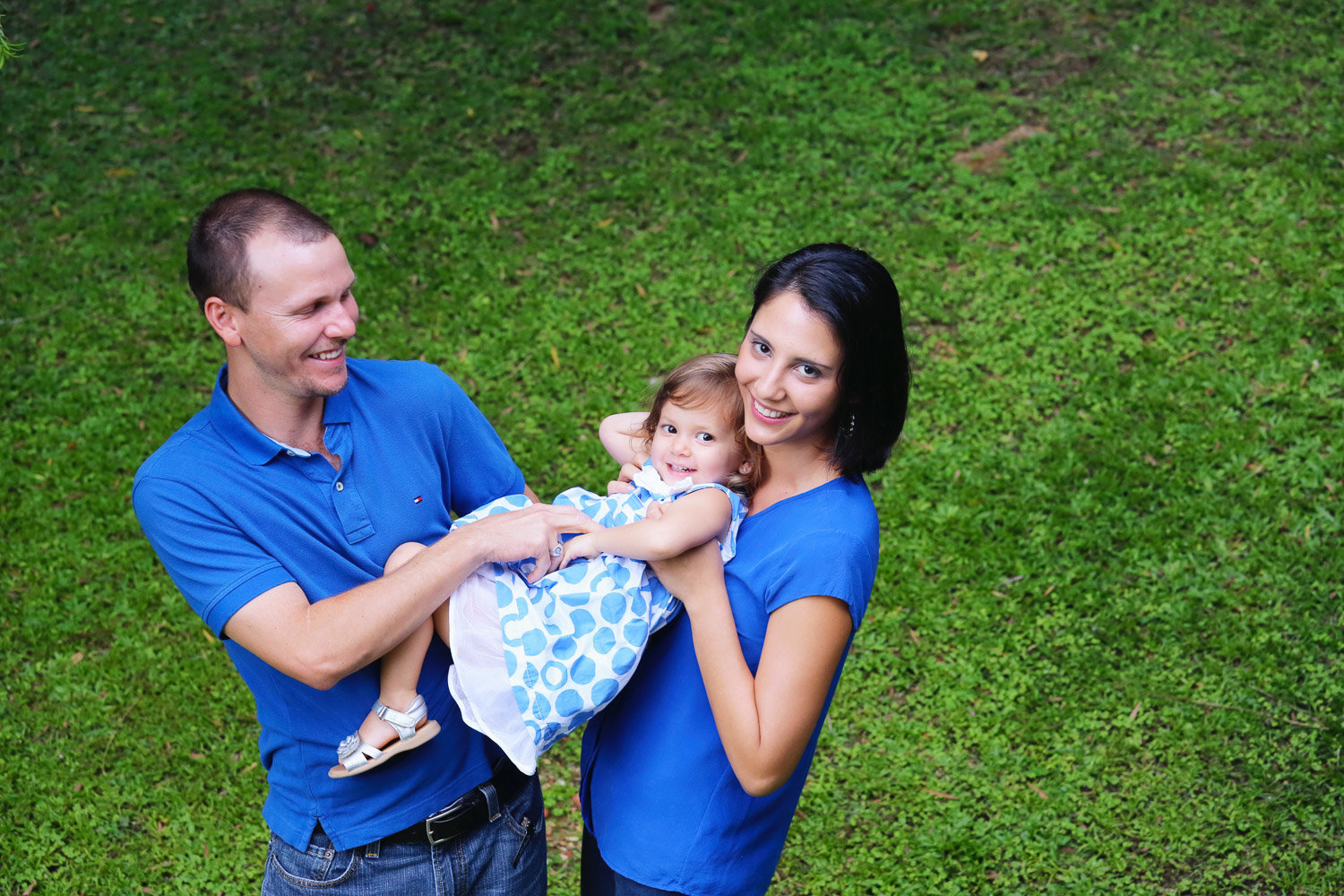 Mom and dad hold daughter while dressed in blue. Photo by Ross Photography, Trinidad, W.I..